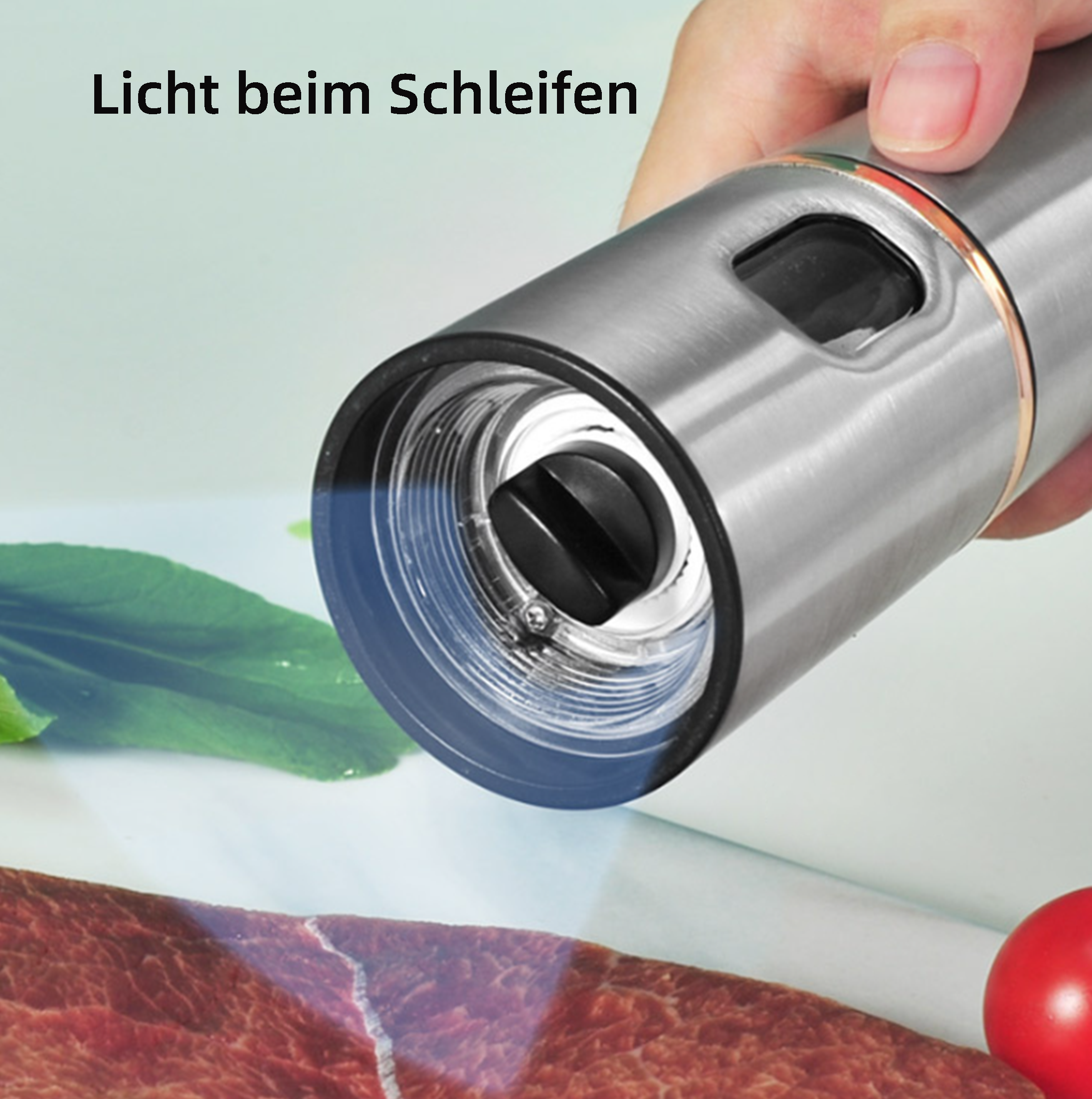 Eine Hand hält einen Grinder über Fleisch, einer Tomate und einem Blatt auf weißem Untergrund. Der Grinder ist silber.
