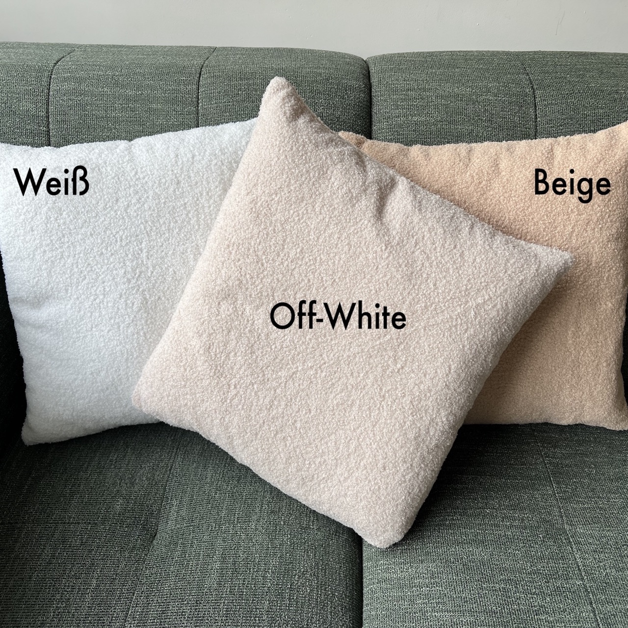 Drei strukturierte Kissen mit den Bezeichnungen 'Weiß', 'Off-White' und 'Beige' liegen auf einem grünen Sofa. Jedes Kissen hat einen anderen Farbton.