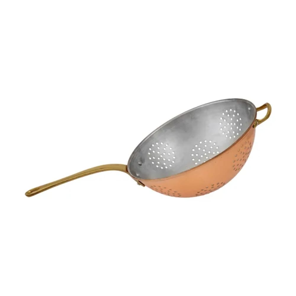 Una scolapasta in rame con manico in ottone, su sfondo bianco. La scolapasta ha molti piccoli fori.
