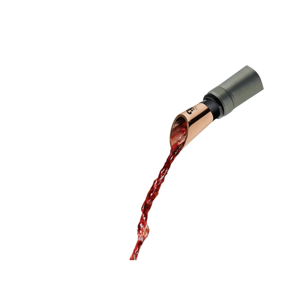 Un aeratore per vino versa vino rosso. L'aeratore è metallico e ha un beccuccio color rame. Il vino scorre verso il basso.