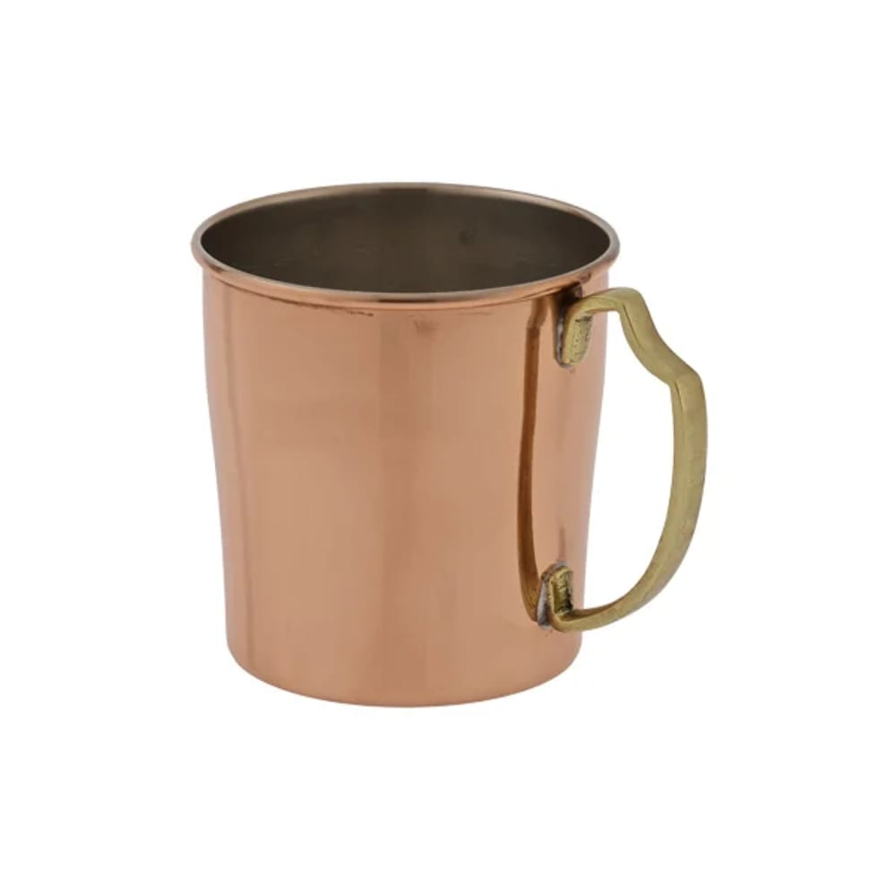 Una tazza di rame con un manico in ottone è mostrata su sfondo bianco. La tazza è cilindrica, con una superficie lucida e un manico in ottone.
