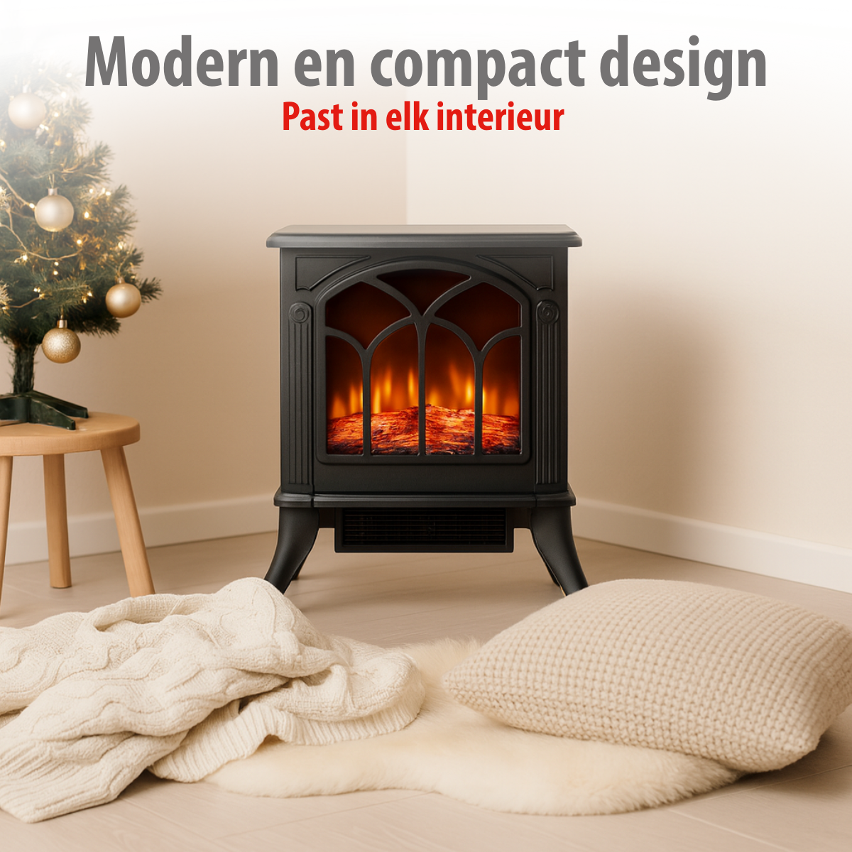 Een zwarte open haard met vuureffect, een kleine kerstboom en een crèmekleurige deken en kussen op de vloer.