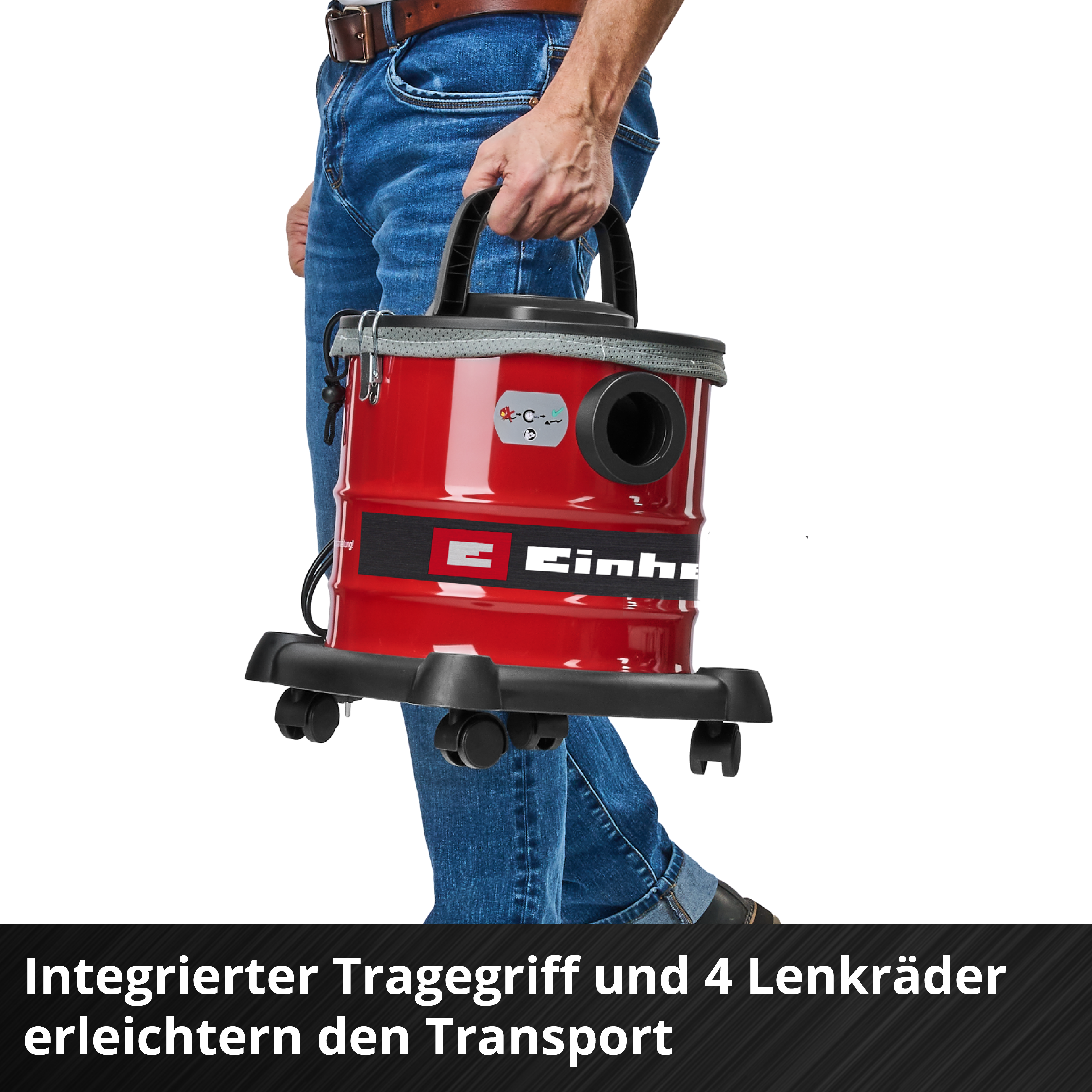 Eine Person hält einen roten Staubsauger. Der Staubsauger hat einen schwarzen Griff und Räder. Die Person trägt Jeans.