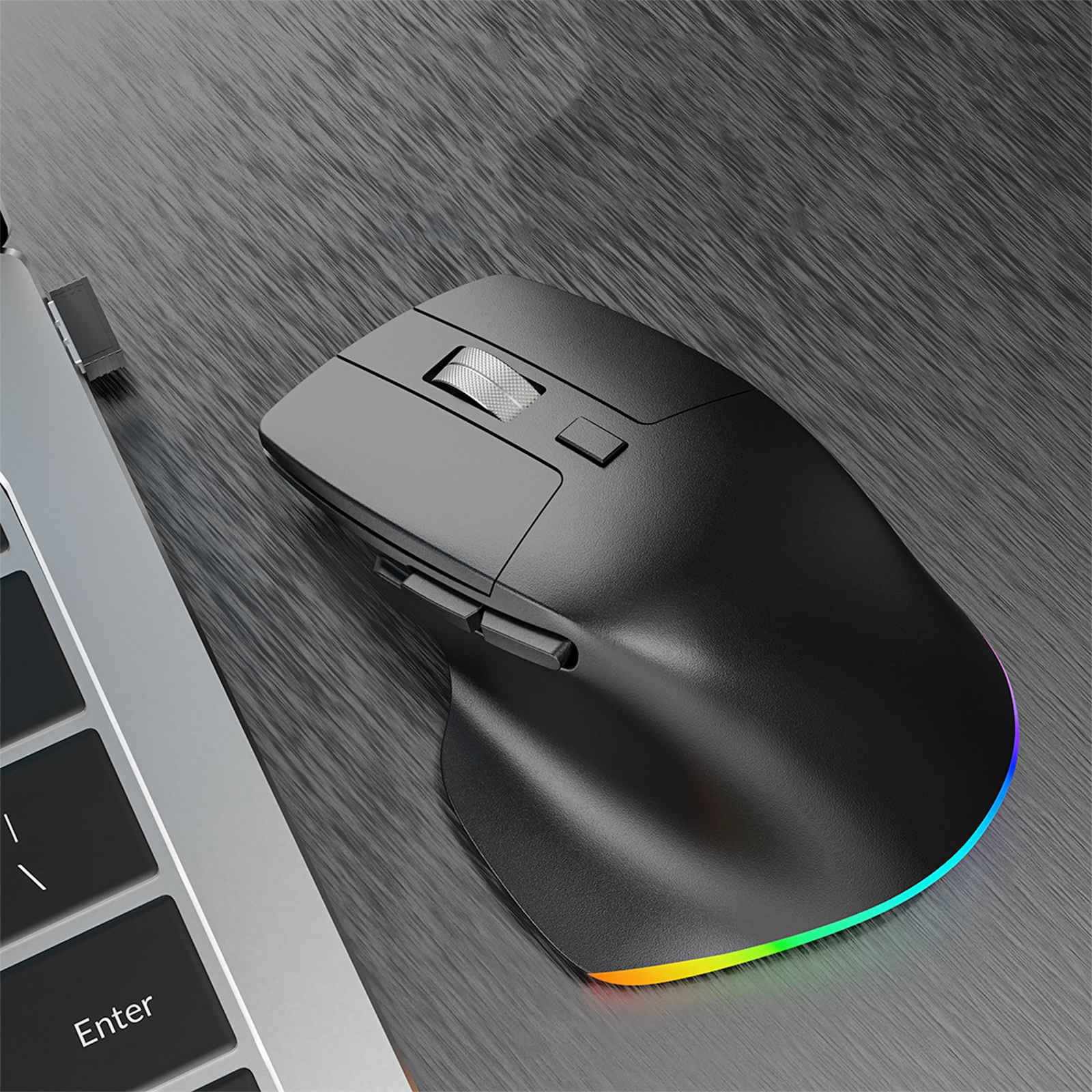 Eine schwarze ergonomische Maus mit einem LED-Rand in Regenbogenfarben liegt neben einer Laptop-Tastatur auf einer grauen Holzoberfläche.
