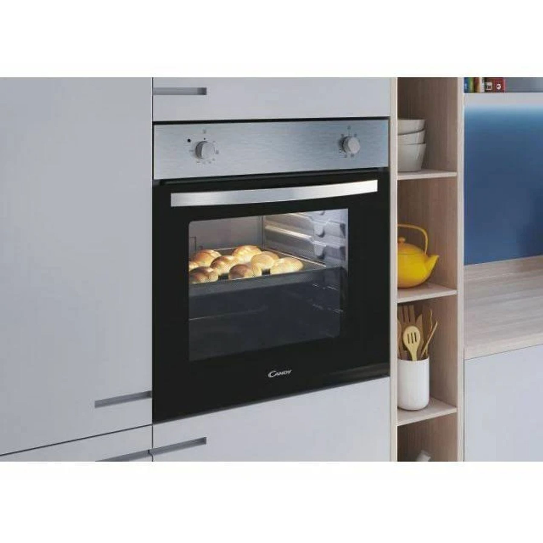 Forno con prodotti da forno. Cucina con mensole, teiera gialla e utensili.
