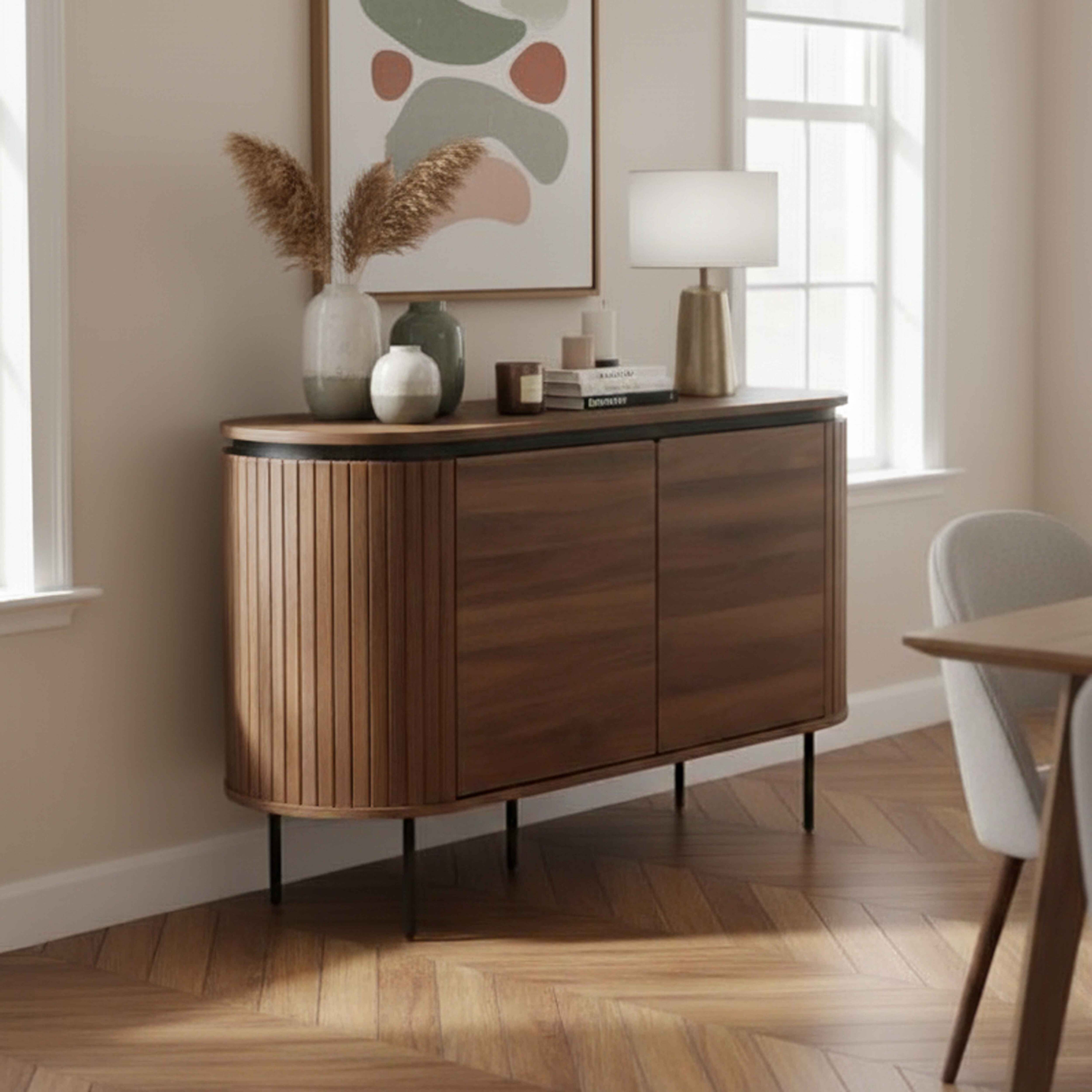 Ein Holzschrank mit Dekoration oben. Ein Gemälde an der Wand. Rechts ein Fenster und ein Esszimmer-Set.