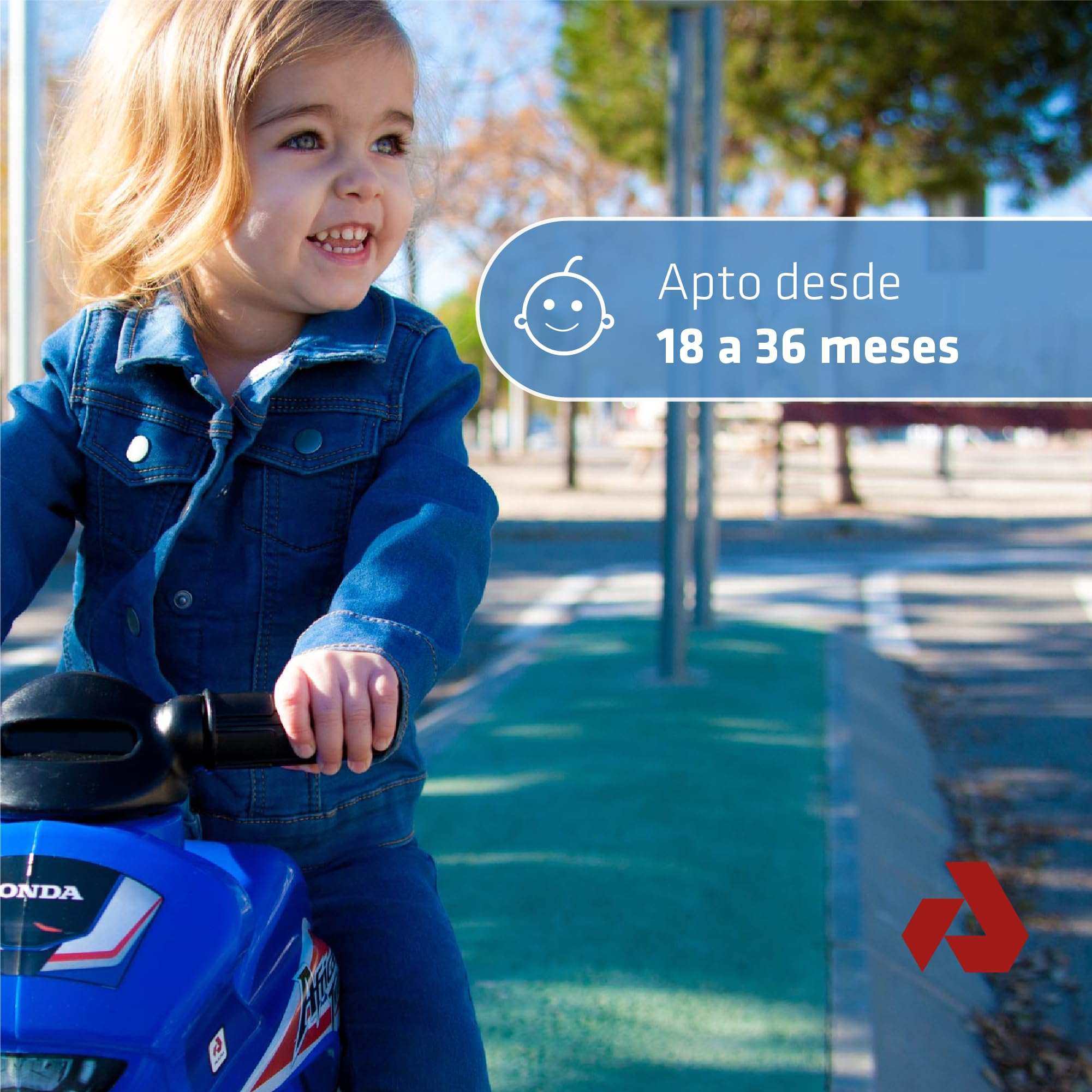 Un bambino sorridente cavalca una moto giocattolo blu. La scena è all'aperto con testo che indica l'età adatta.