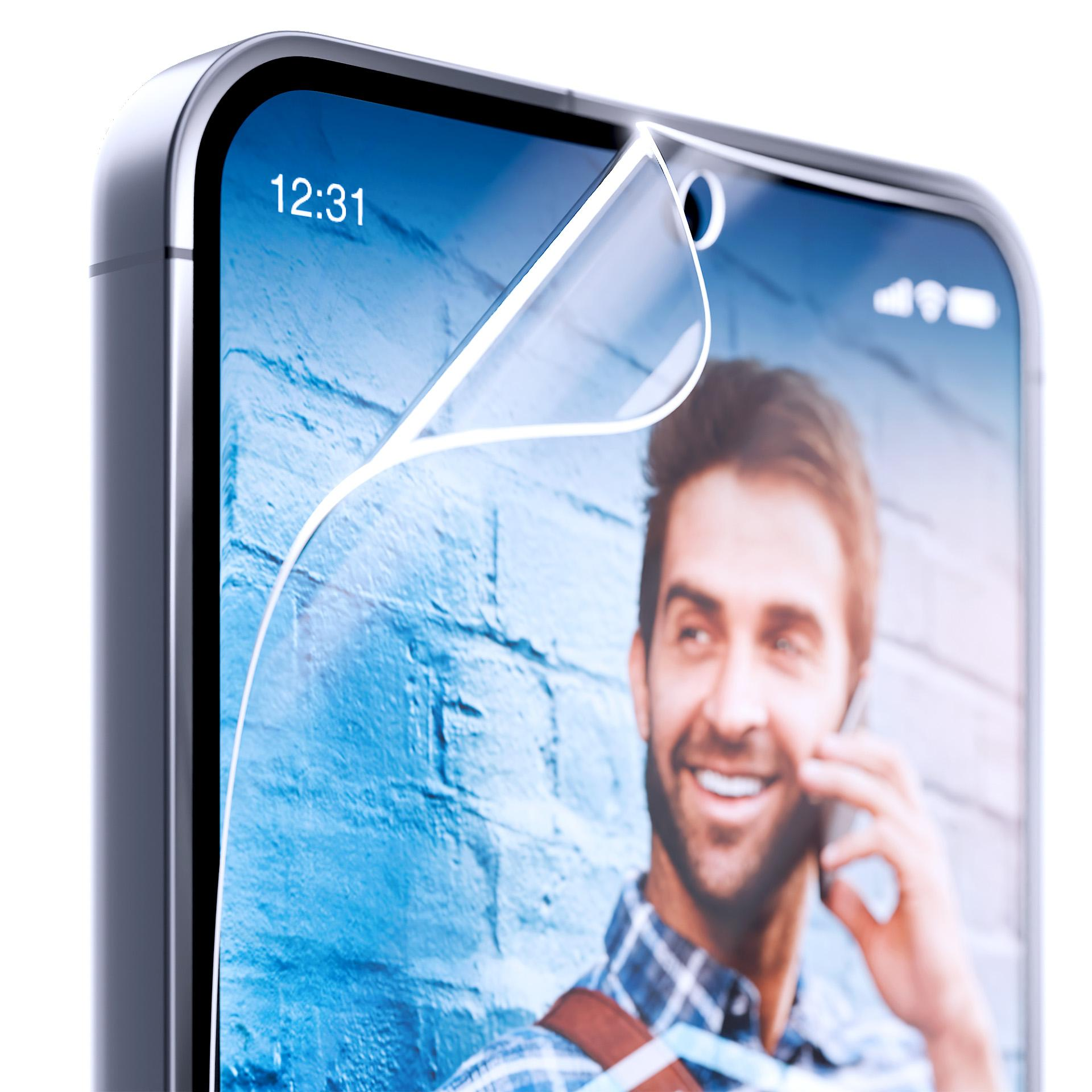 Smartfon z folią ochronną, pokazujący mężczyznę podczas rozmowy i godzinę 12:31. Tło niebieskiej ceglanej ściany.