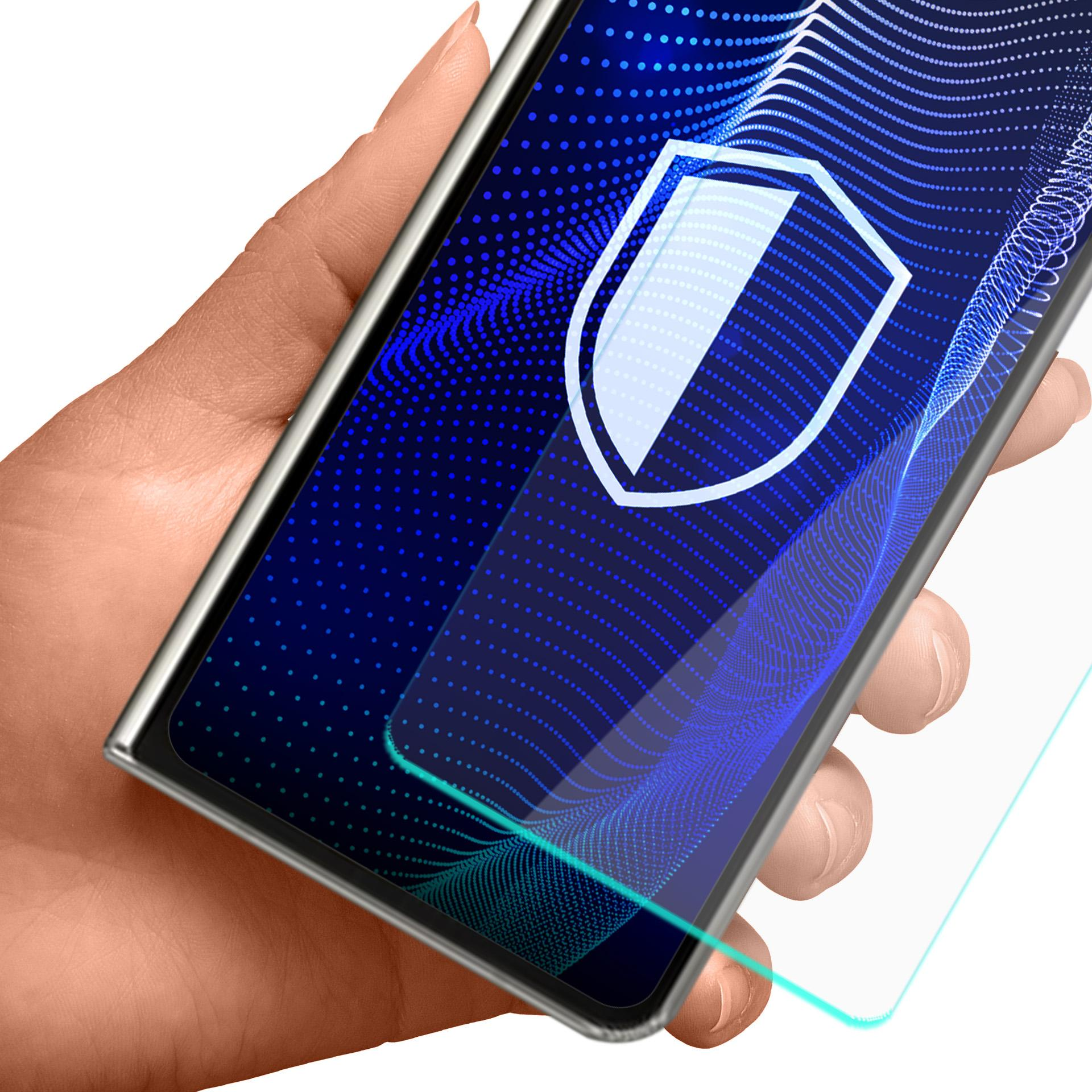 Dłoń trzymająca telefon z tarczą na ekranie, nakładana jest ochrona.