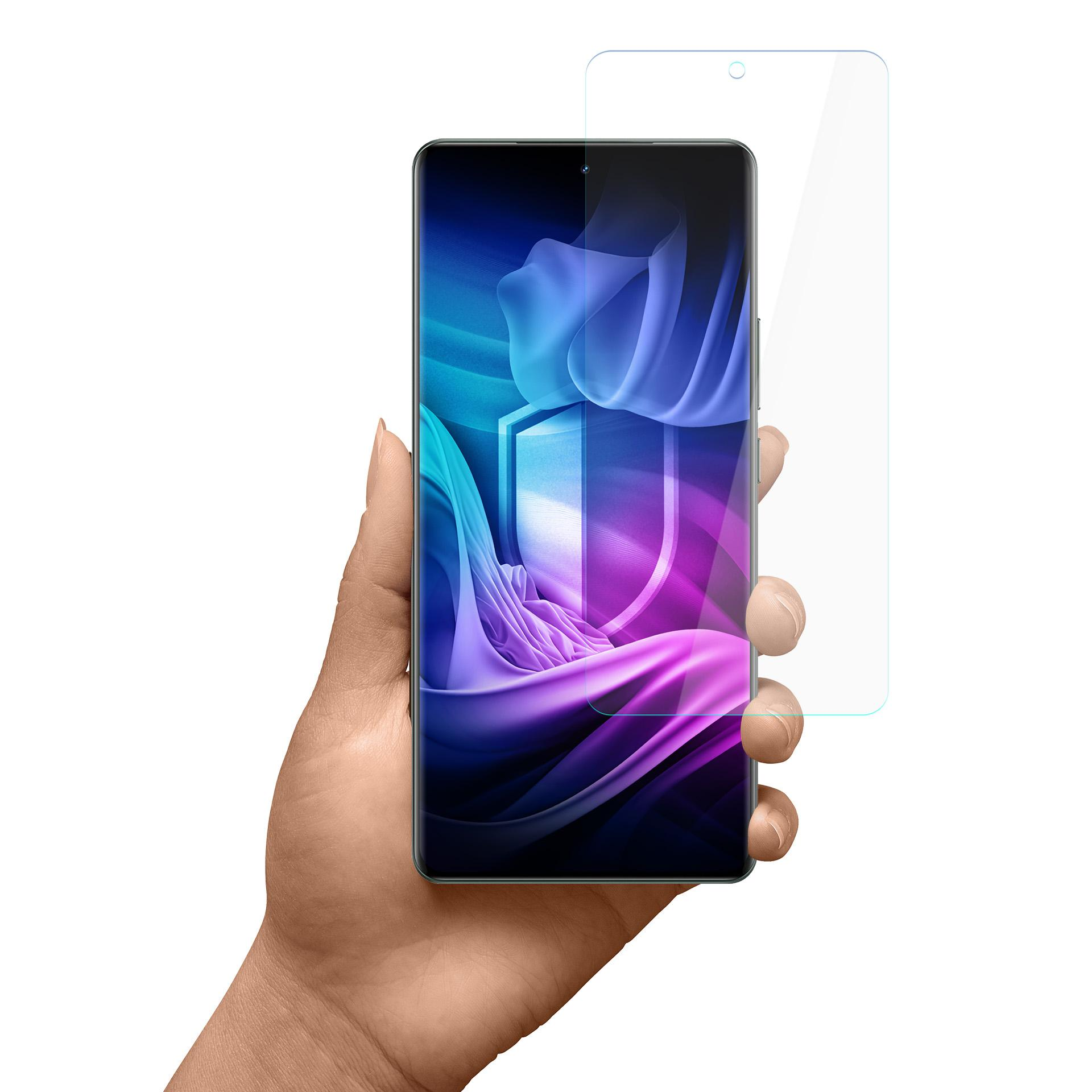 Mano che tiene uno smartphone con una protezione schermo. Lo schermo mostra un design viola e blu. Sfondo bianco.