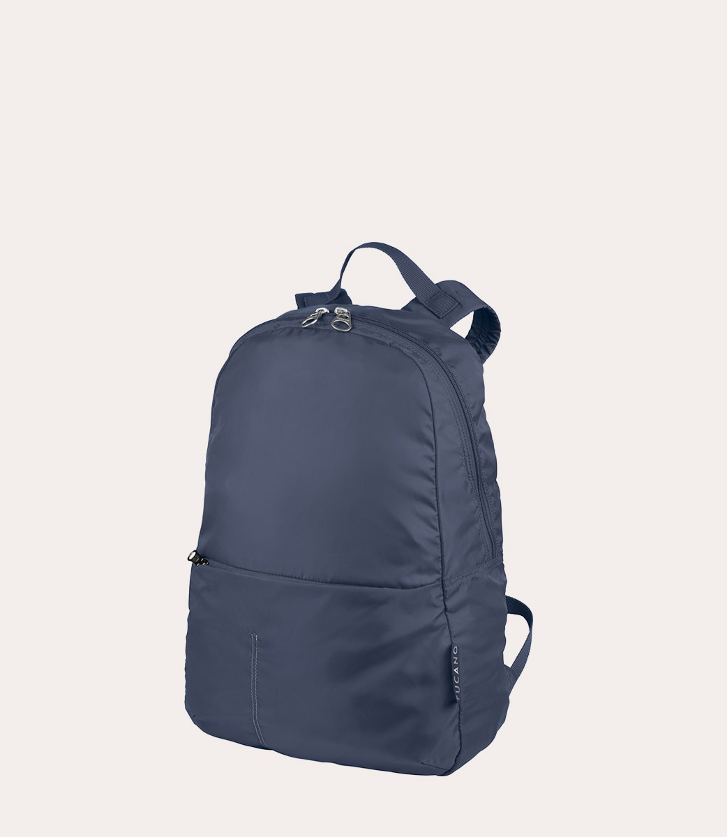 Ein marineblauer Rucksack steht vor einem hellbeigen Hintergrund. Er hat einen oberen Griff und einen Reißverschluss. Der Markenname 'Tucano' ist sichtbar.