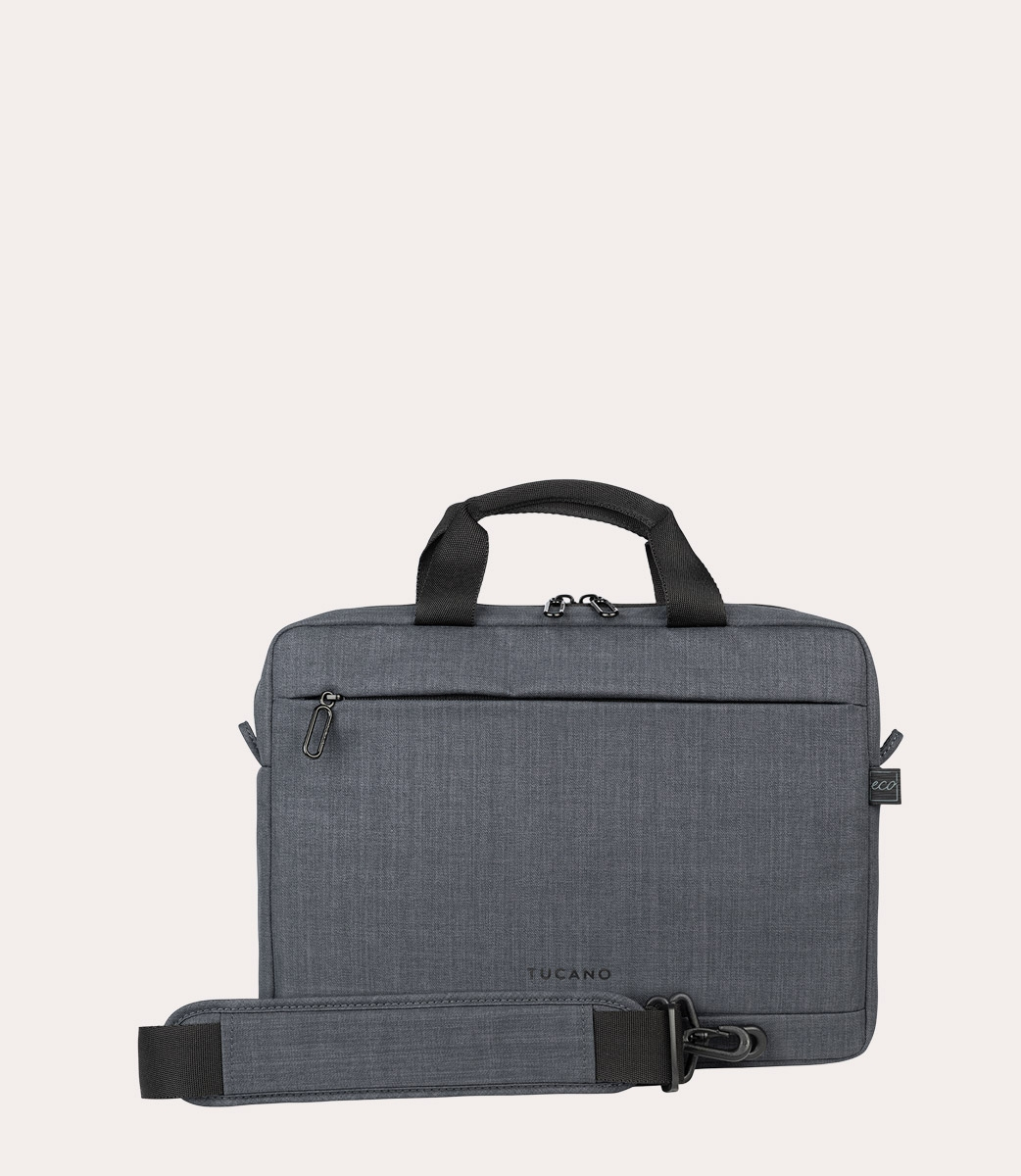 Una borsa per laptop Tucano grigia con manico nero, tracolla e cerniere. Lo sfondo è di un colore bianco sporco.