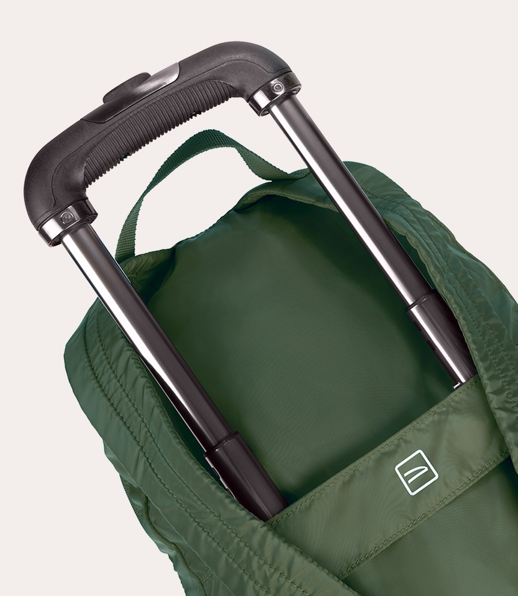 Nahaufnahme einer grünen Reisetasche mit ausziehbarem schwarzem Griff. Silberne Metallstangen stützen den Griff. Die Tasche hat ein weißes Logo.