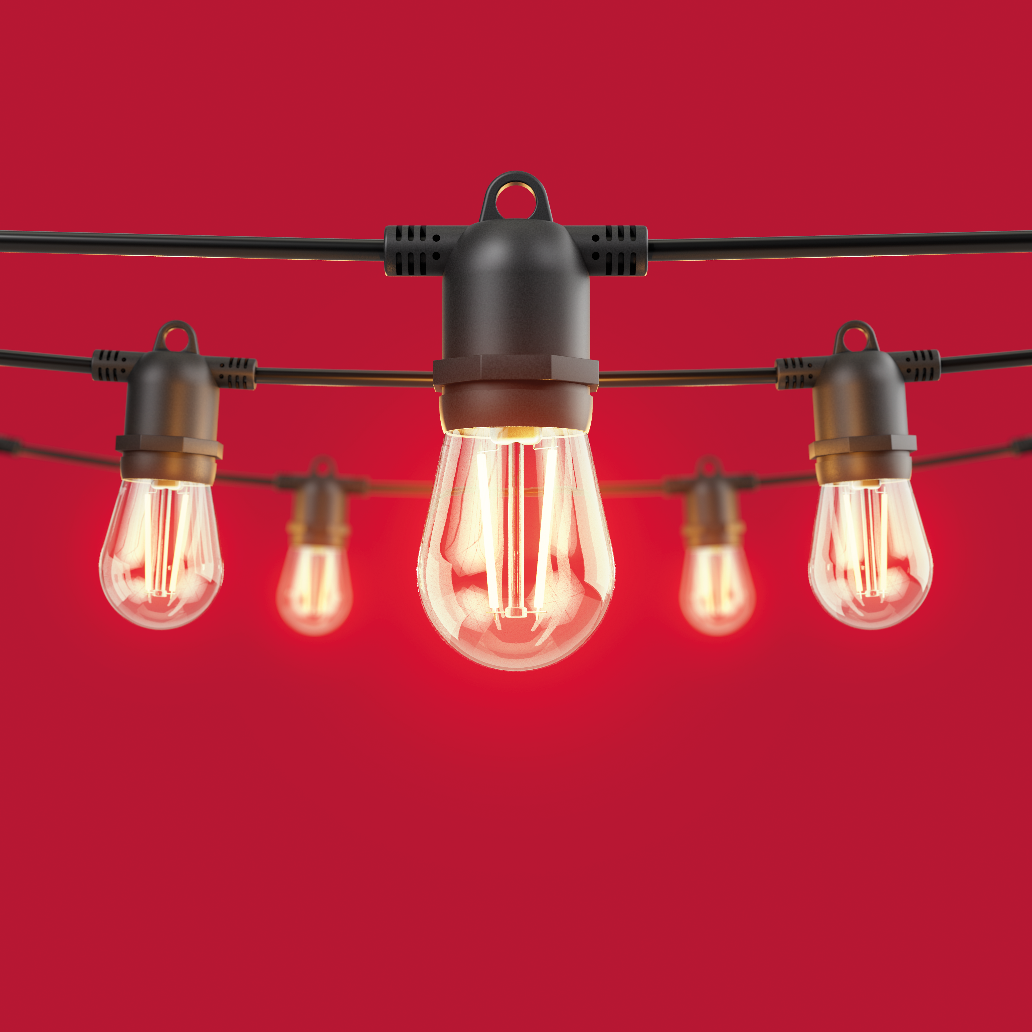 String lights with glowing bulbs against a red background. The bulbs are teardrop-shaped.