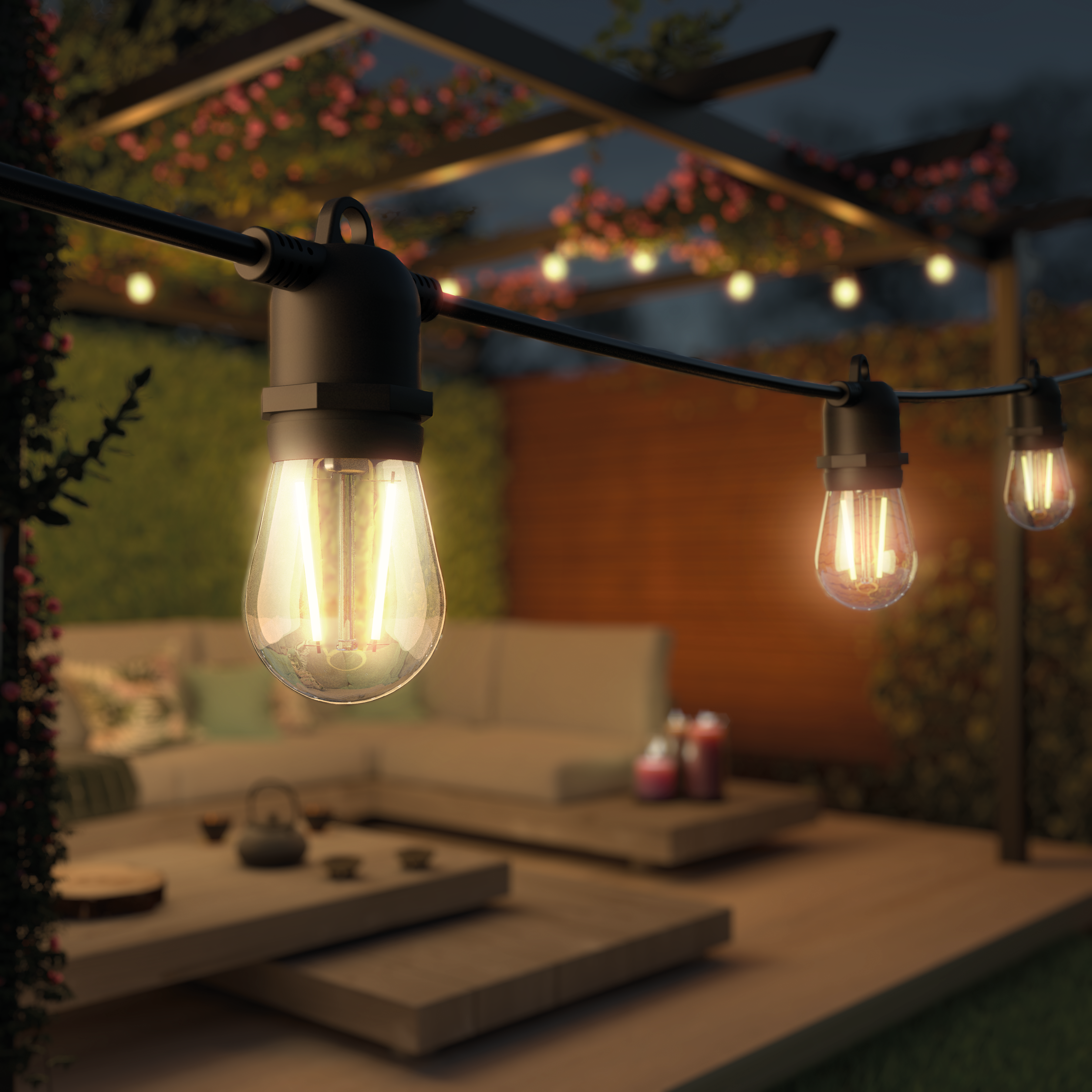 String lights illuminate a patio at dusk. A sofa, table, and plants are in the background. Warm, inviting ambiance.