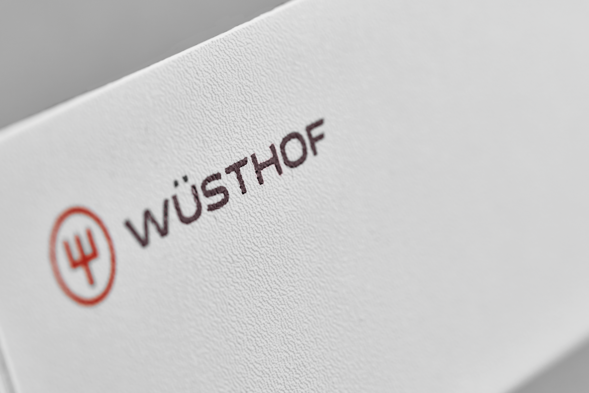 Nahaufnahme einer weißen, strukturierten Oberfläche mit dem Markennamen WÜSTHOF in braunen Buchstaben.