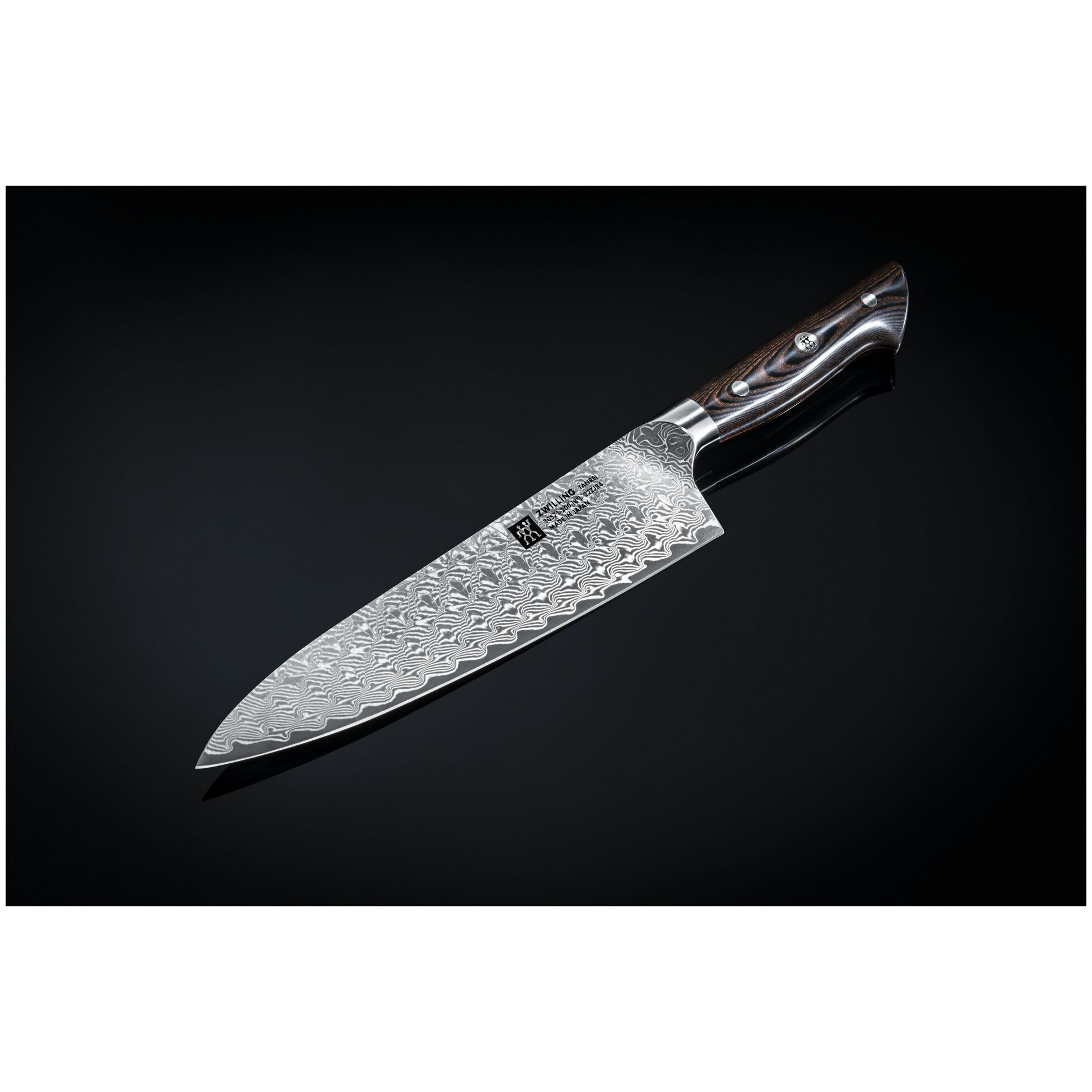 Nóż szefa kuchni z wzorzystym ostrzem i drewnianą rękojeścią na odblaskowym czarnym tle.