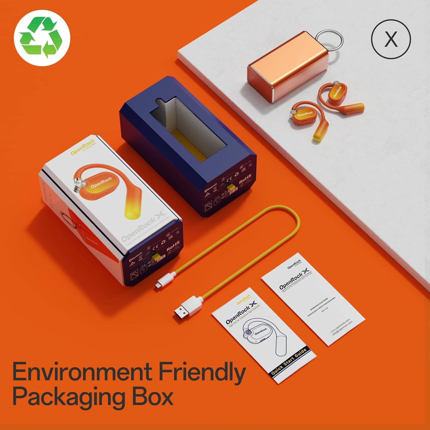 An orange and yellow OpenRock earbuds set with packaging and accessories on an orange background. The box says 'Environment Friendly'.