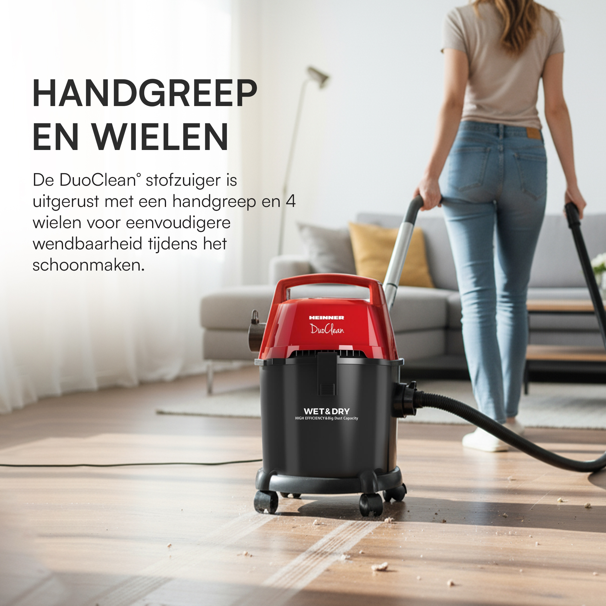 Eine Frau saugt mit einem rot-schwarzen Staubsauger einen Raum. Der Staubsauger steht auf einem Holzboden.
