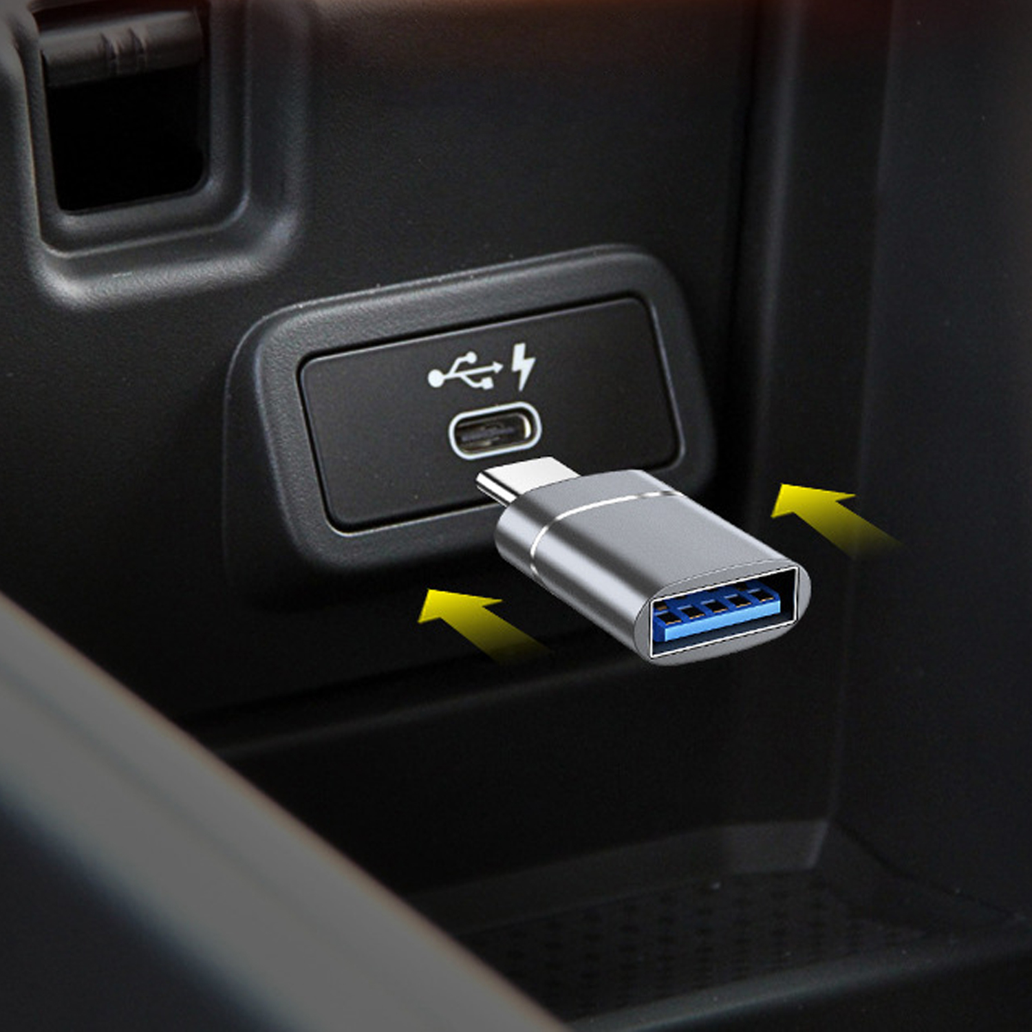 Adapter USB jest podłączony do portu USB-C. Adapter jest srebrny z niebieskim portem USB. Strzałki wskazują na adapter.