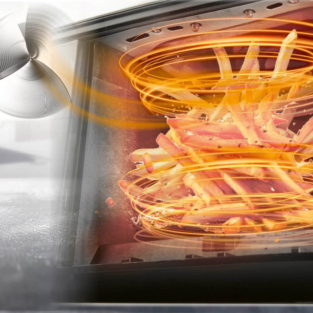 Pommes Frites werden in einem Ofen gegart, mit Hitze- und Lüftereffekt. Die Pommes sind golden, der Ofen dunkel und der Lüfter silbern.
