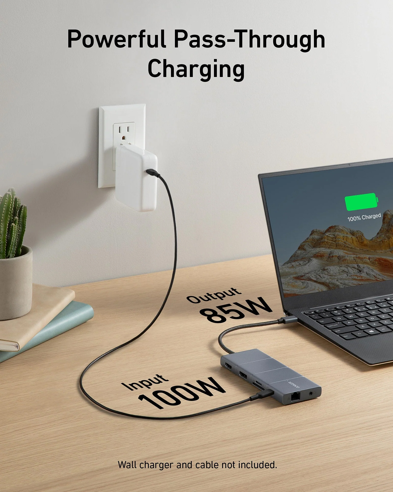 Un laptop si sta caricando tramite un hub collegato a una presa a muro. Il laptop mostra il 100% di carica.