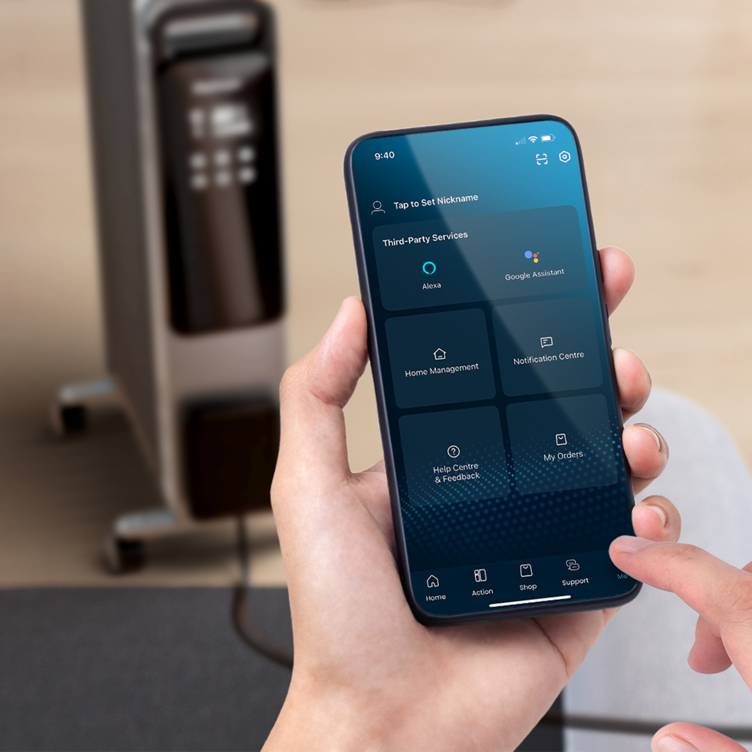 Eine Hand hält ein Smartphone mit App-Steuerung, im Hintergrund ein Heizgerät. Der Bildschirm zeigt App-Funktionen wie Alexa und Google Assistant.