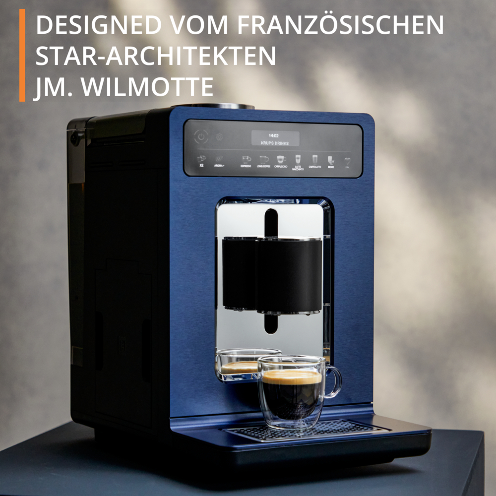 Una macchina da caffè blu e nera con un bicchiere di caffè davanti. Testo: Progettato dall'architetto star francese JM. Wilmotte.