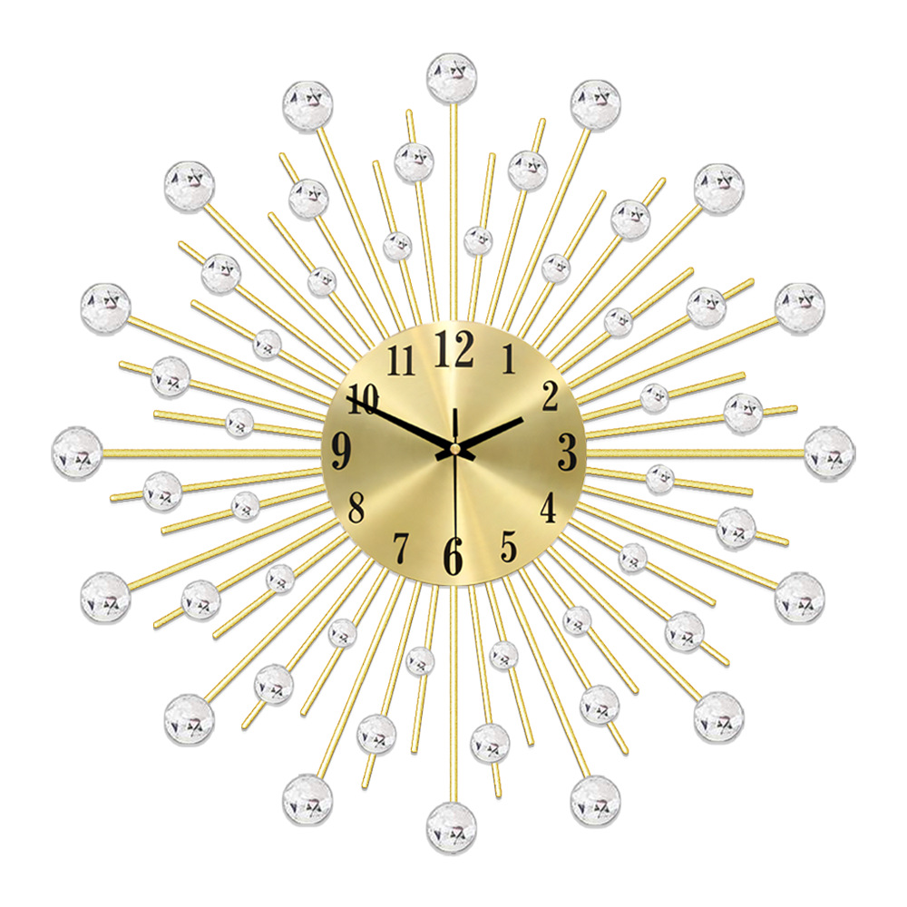 Eine goldene Wanduhr mit Sonnenstrahlendesign. Sie hat ein goldenes Zifferblatt mit schwarzen Zahlen und Zeigern sowie Kristallakzenten.