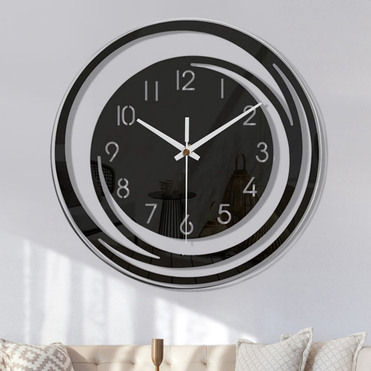Eine moderne schwarz-weiße Uhr an einer weißen Wand. Die Uhr hat ein Spiraldesign und weiße Zeiger. Im Vordergrund befindet sich ein Sofa.