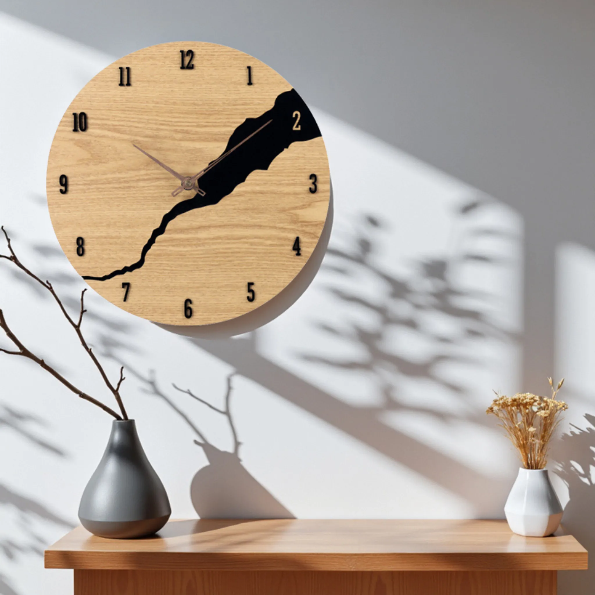 Eine Holzuhr mit schwarzem Design, eine Vase mit Ästen und eine weitere mit getrockneten Blumen auf einem Holztisch.