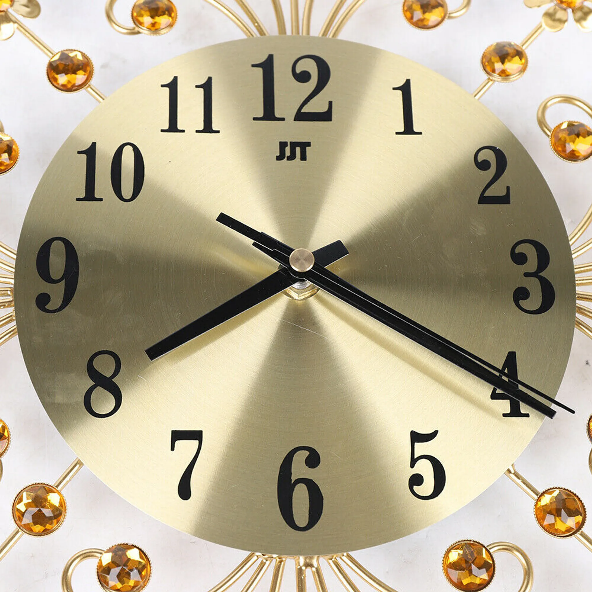 Goldene Uhr mit schwarzen Zahlen und Zeigern. Goldene Edelsteine umgeben das Zifferblatt.