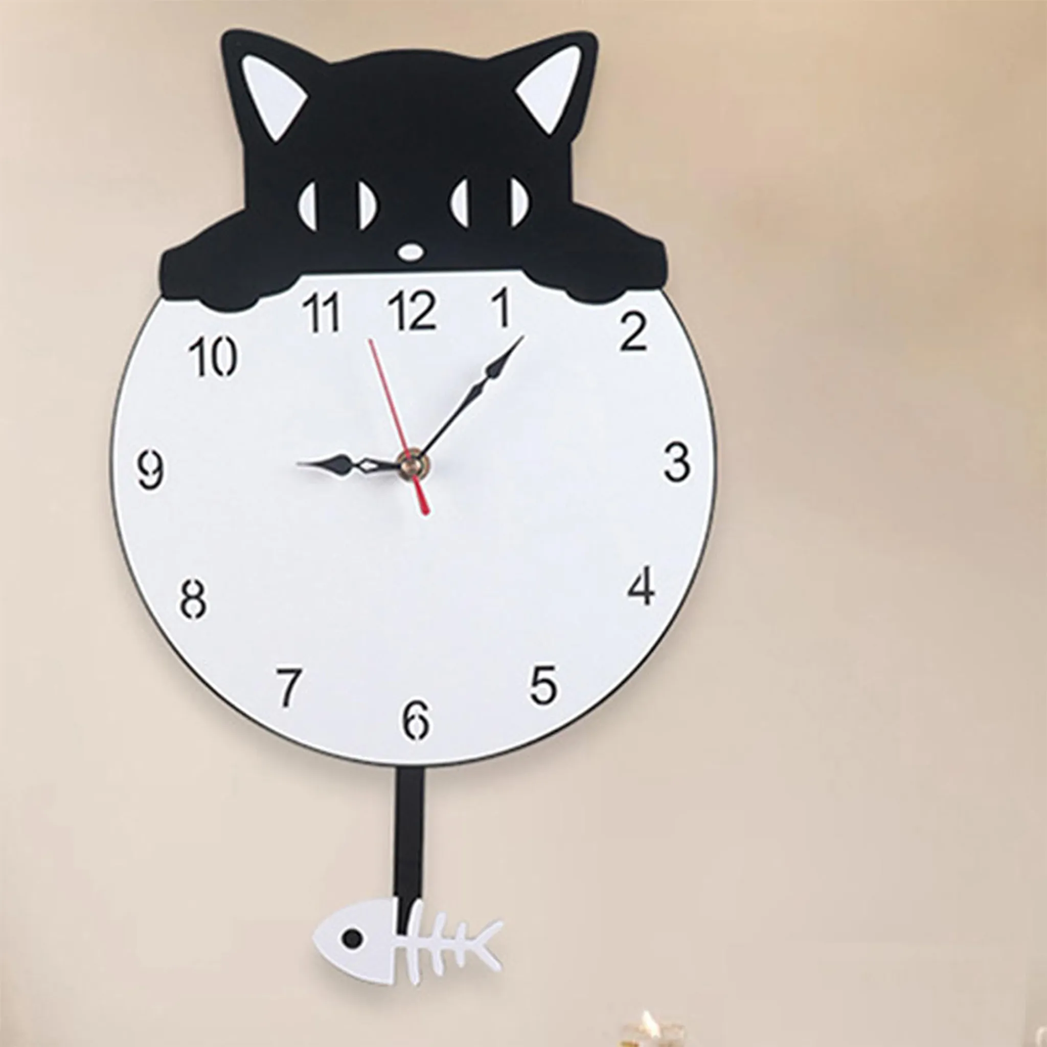 Eine katzenförmige Wanduhr mit weißem Zifferblatt und schwarzer Katzenumrandung. Das Pendel ist ein Fisch.