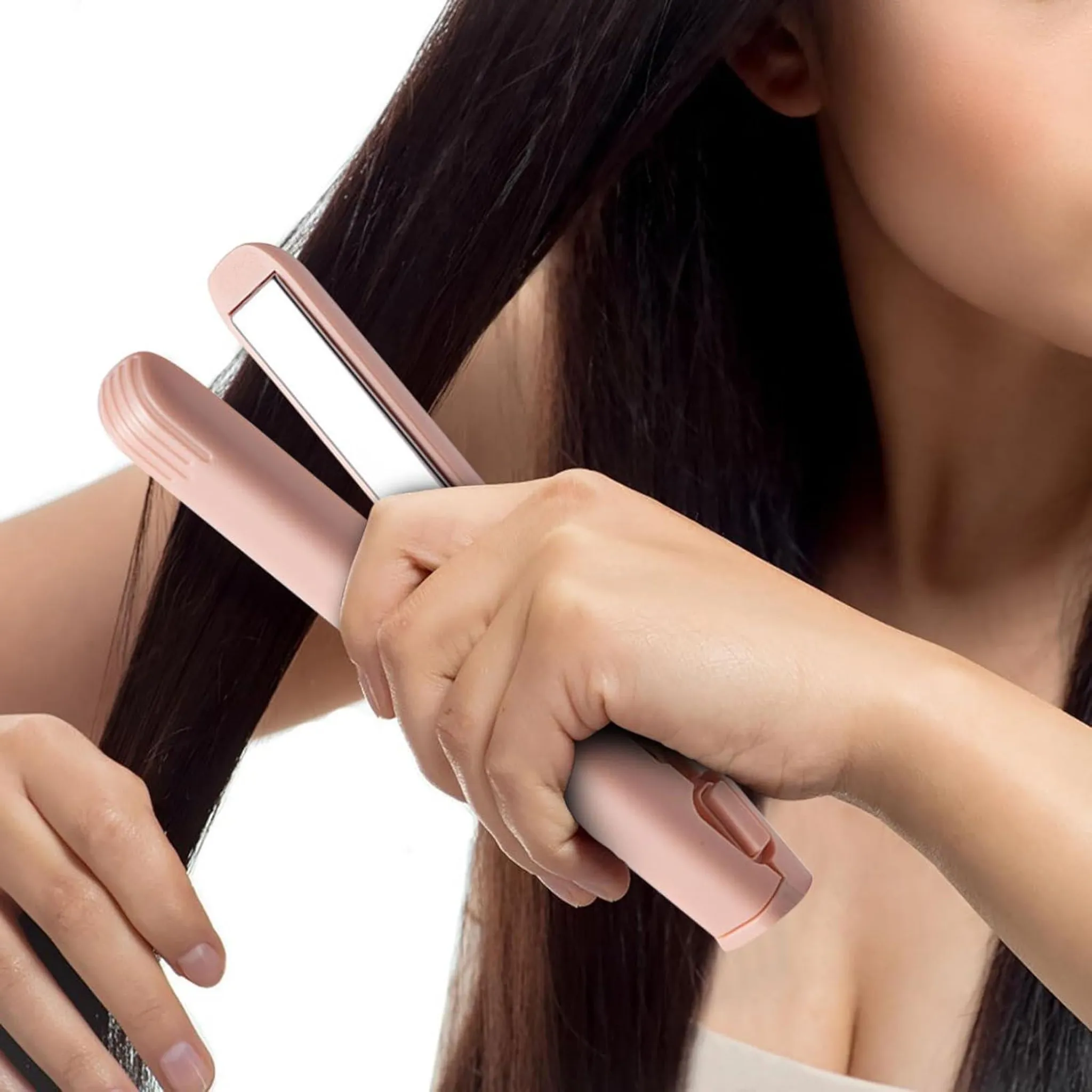 Eine Person verwendet einen rosa Haarglätter auf dunklem Haar. Das Gerät ist geöffnet und glättet einen Haarabschnitt.