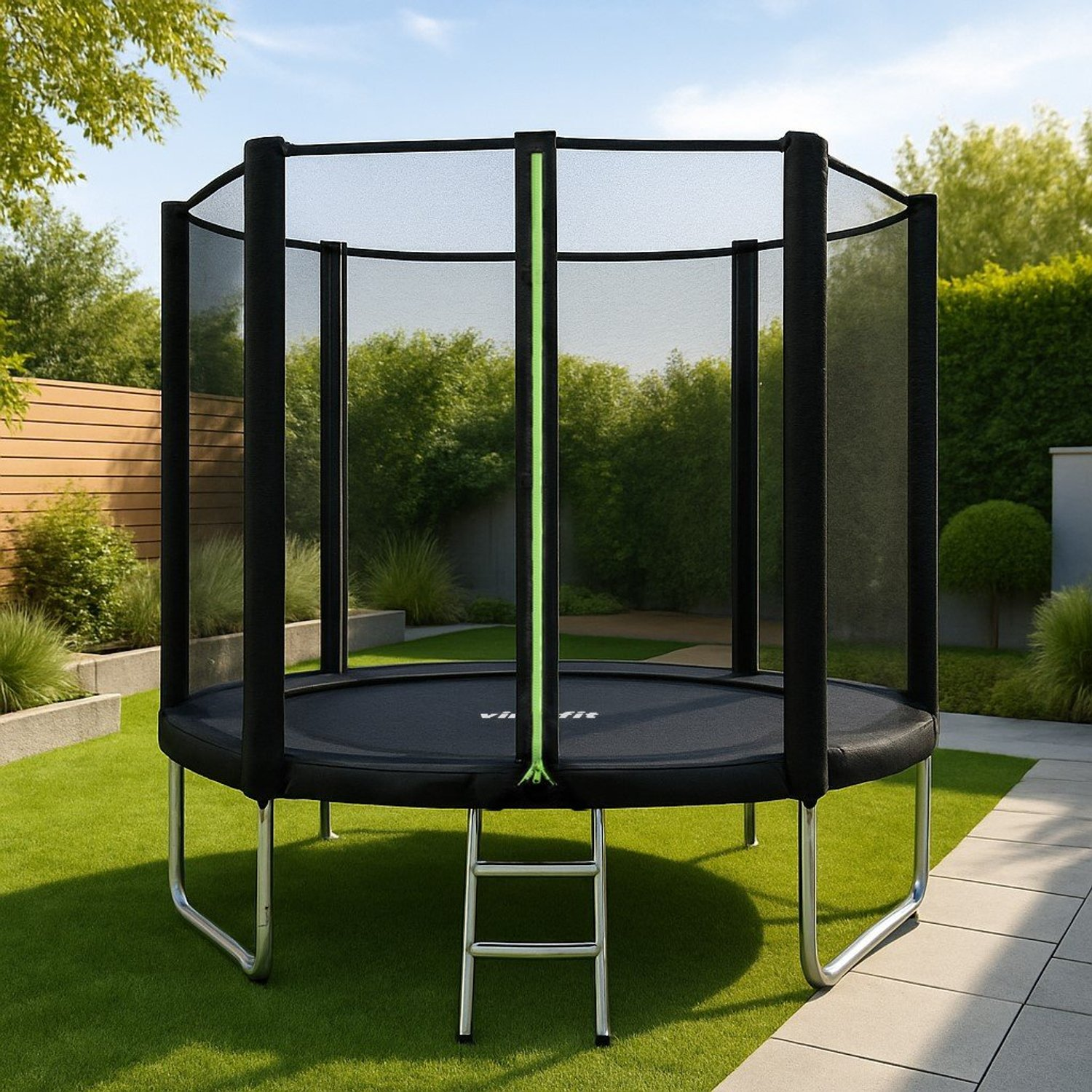 Ein schwarzes Trampolin mit grünen Akzenten steht auf grünem Gras. Es hat ein Sicherheitsnetz und eine kleine Leiter. Bäume und blauer Himmel im Hintergrund.