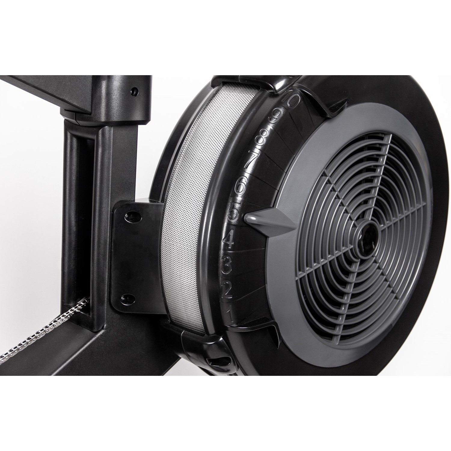 Nahaufnahme eines schwarzen Rudergerät-Schwungrads mit Ventilator. Zahlen und ein silbernes Netz sind sichtbar. Auch eine Kette ist vorhanden.