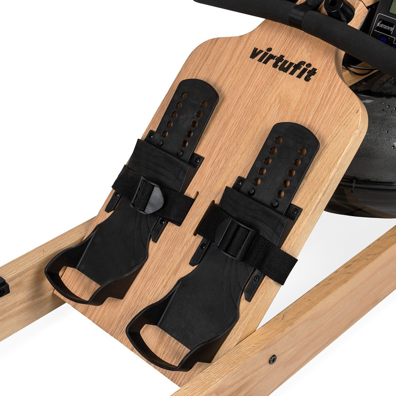 Primo piano di un vogatore in legno con supporti per i piedi e cinghie nere. Il marchio 'virtufit' è visibile.