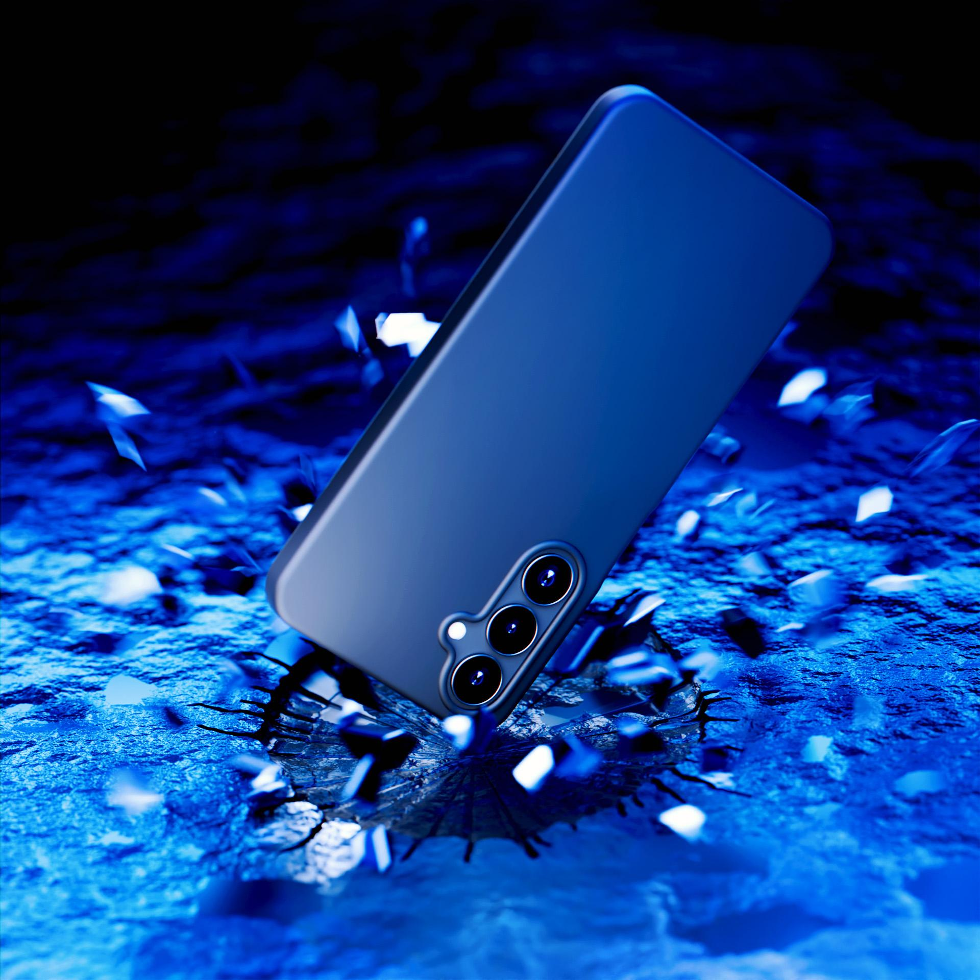 Una custodia blu per telefono che cade su una superficie blu strutturata, con pezzi rotti. Sfondo scuro.