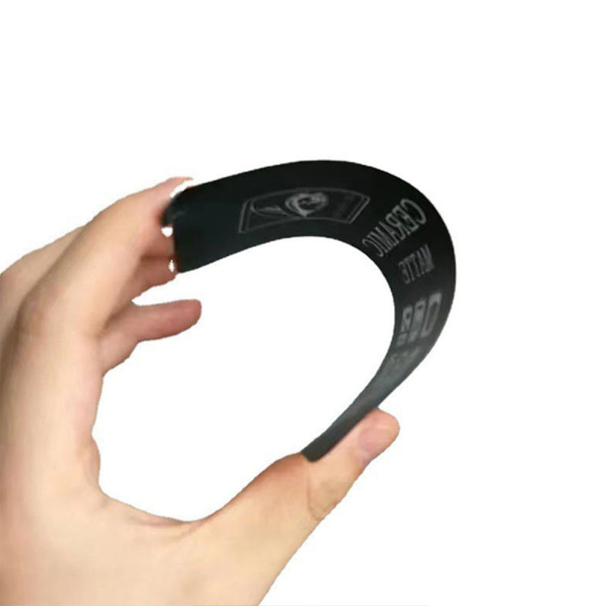 Una mano tiene un oggetto nero flessibile, curvo. C'è del testo stampato sopra, tra cui le parole 'ceramic' e '800'.