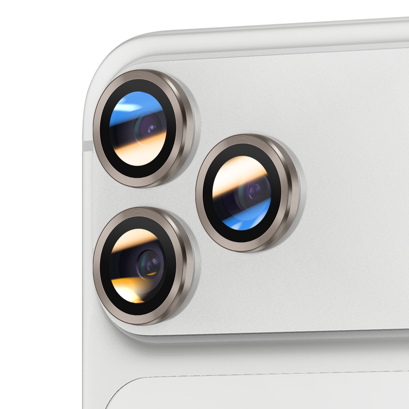 Gros plan du système de caméras d'un téléphone. Trois lentilles avec des anneaux argentés sont visibles, sur une surface blanche.