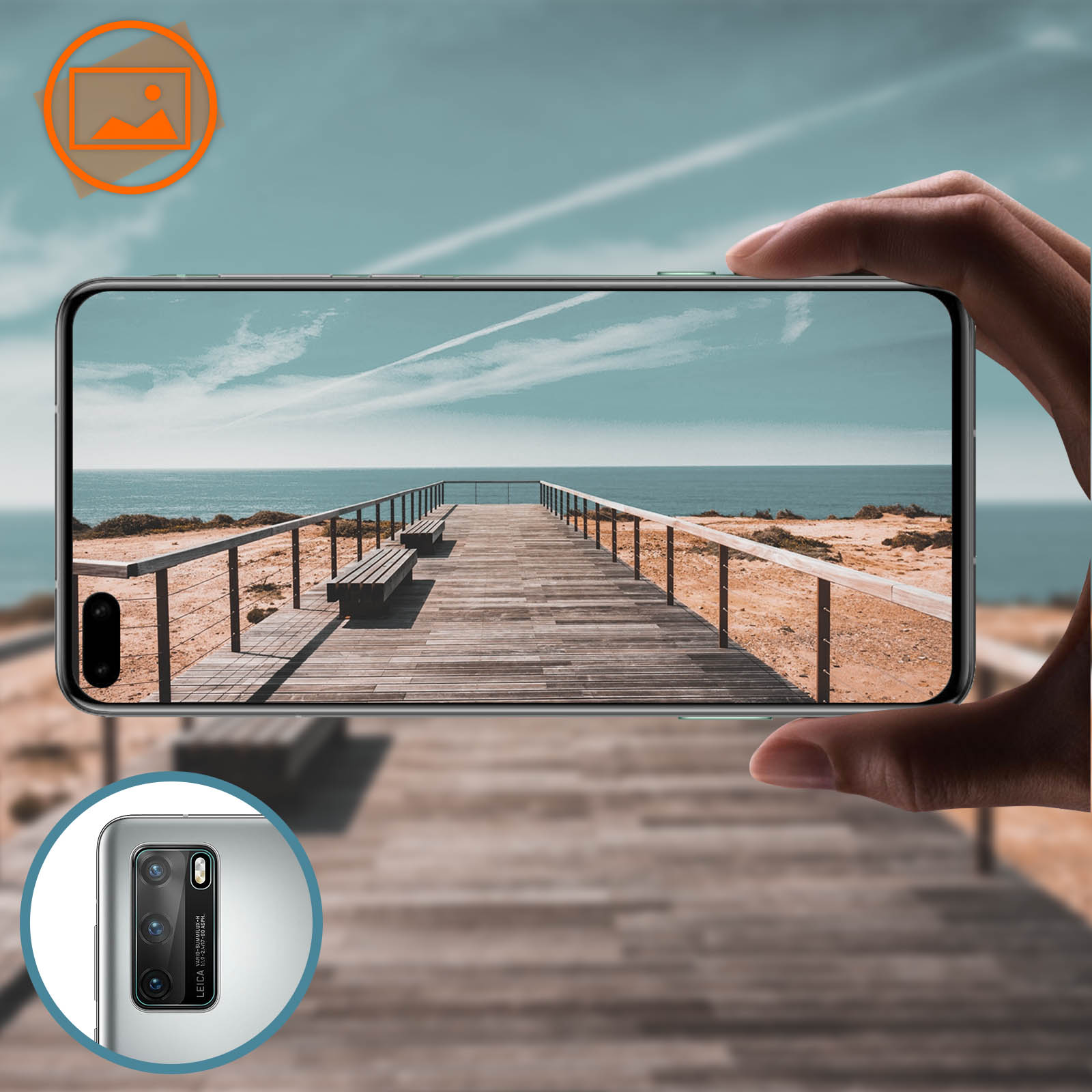 Una mano che tiene un telefono, che mostra una passerella di legno sul mare. È visibile una lente della fotocamera. Un'icona immagine è in alto.