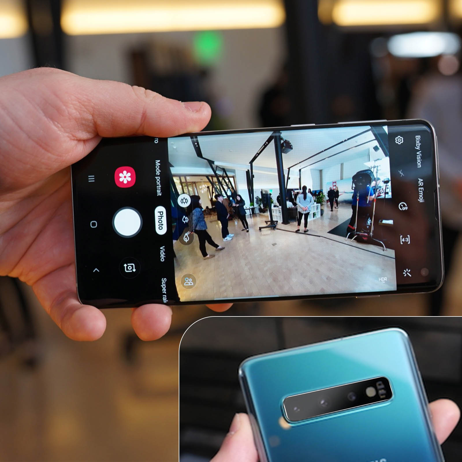 Una mano che tiene un telefono, che mostra una foto di persone in una stanza. La fotocamera del telefono è attiva, con la modalità foto selezionata.