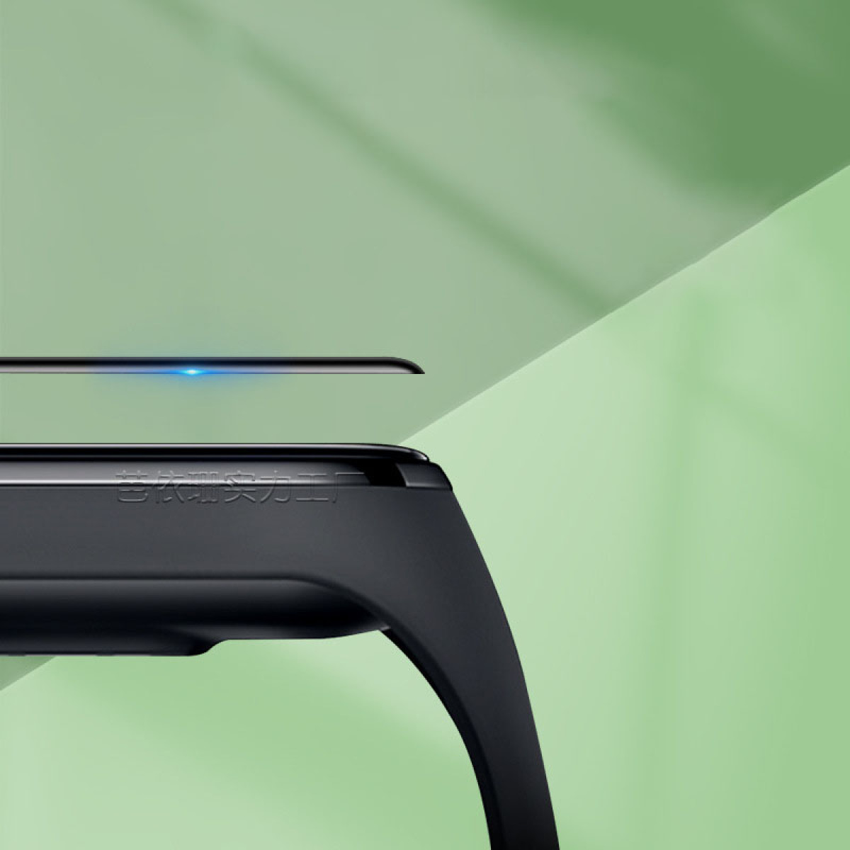 Un primo piano di uno smartwatch nero con una protezione per lo schermo sopra. Lo sfondo è un gradiente di colori verdi.