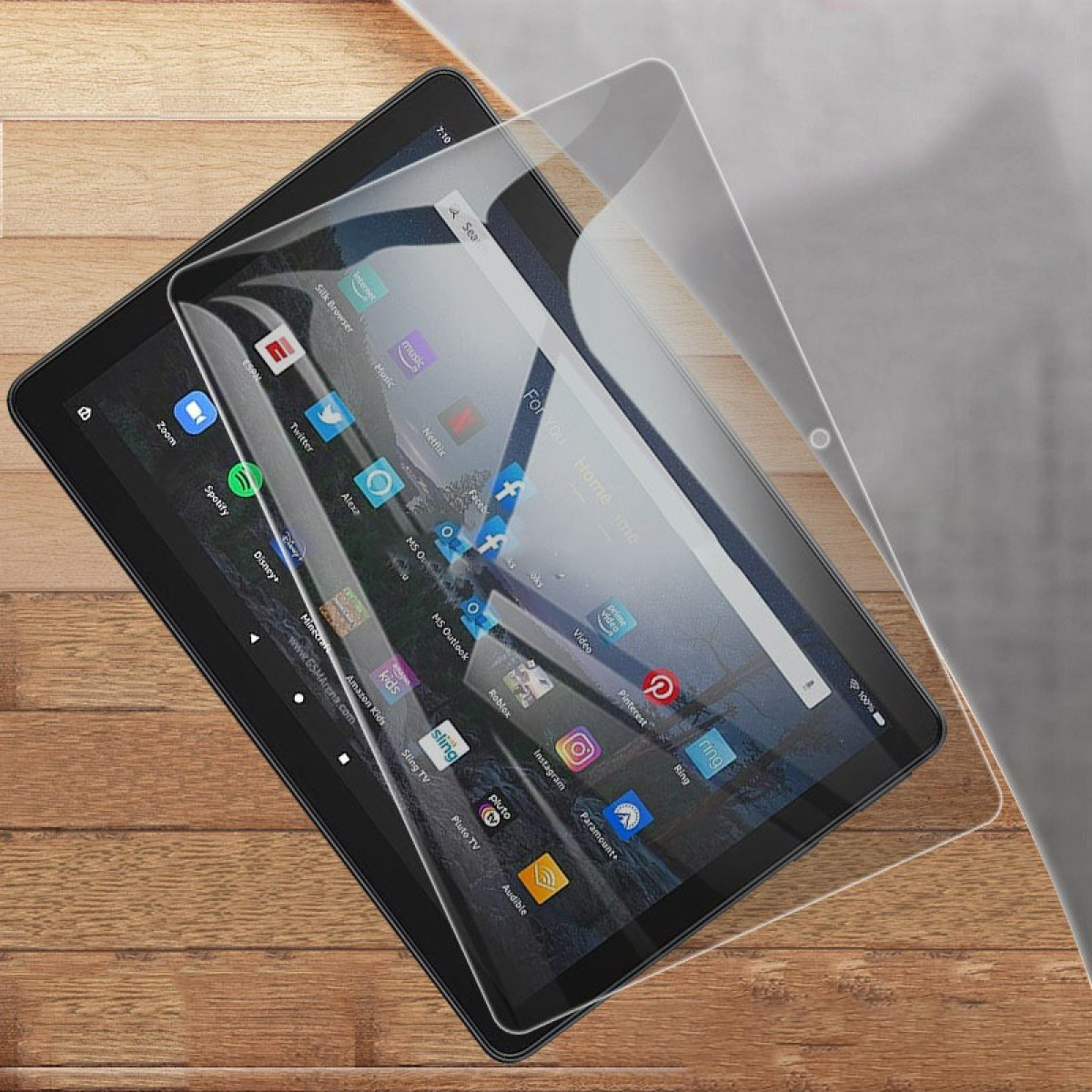 Un tablet con app come Netflix e Spotify è appoggiato su una superficie di legno. Una protezione schermo trasparente è parzialmente staccata.
