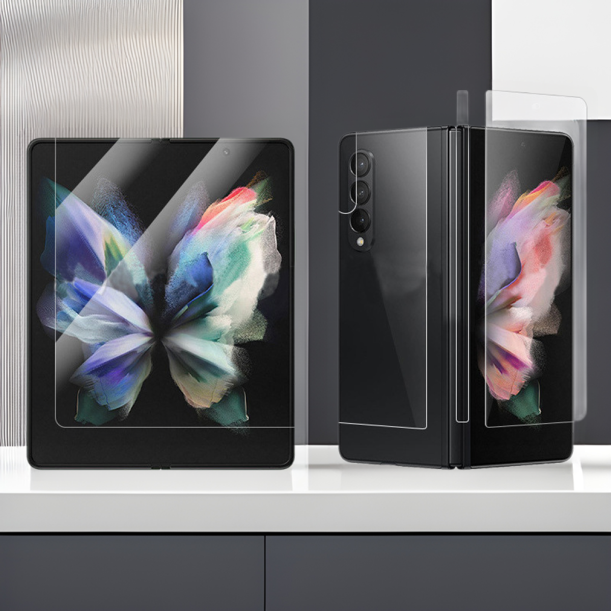 Sono esposti due telefoni pieghevoli neri. Uno è aperto, mostrando un'immagine floreale colorata, e l'altro è parzialmente chiuso.