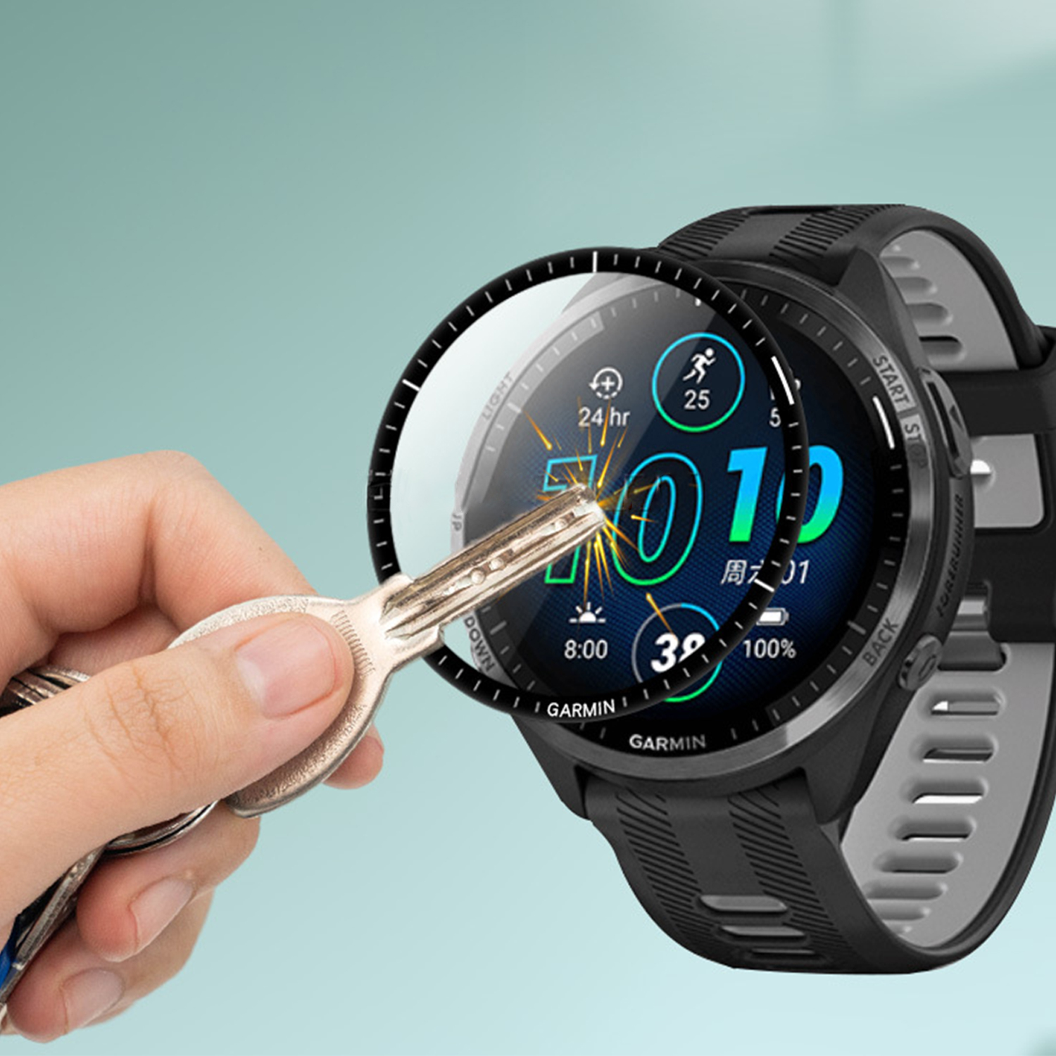 Una mano tiene delle chiavi vicino a uno smartwatch nero che mostra dati, tra cui ora, passi e durata della batteria, su sfondo verde acqua.