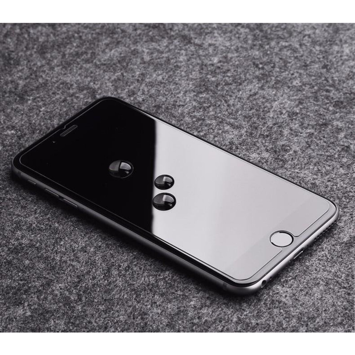 Uno smartphone con gocce d'acqua sullo schermo. È posizionato su una superficie grigia e strutturata.