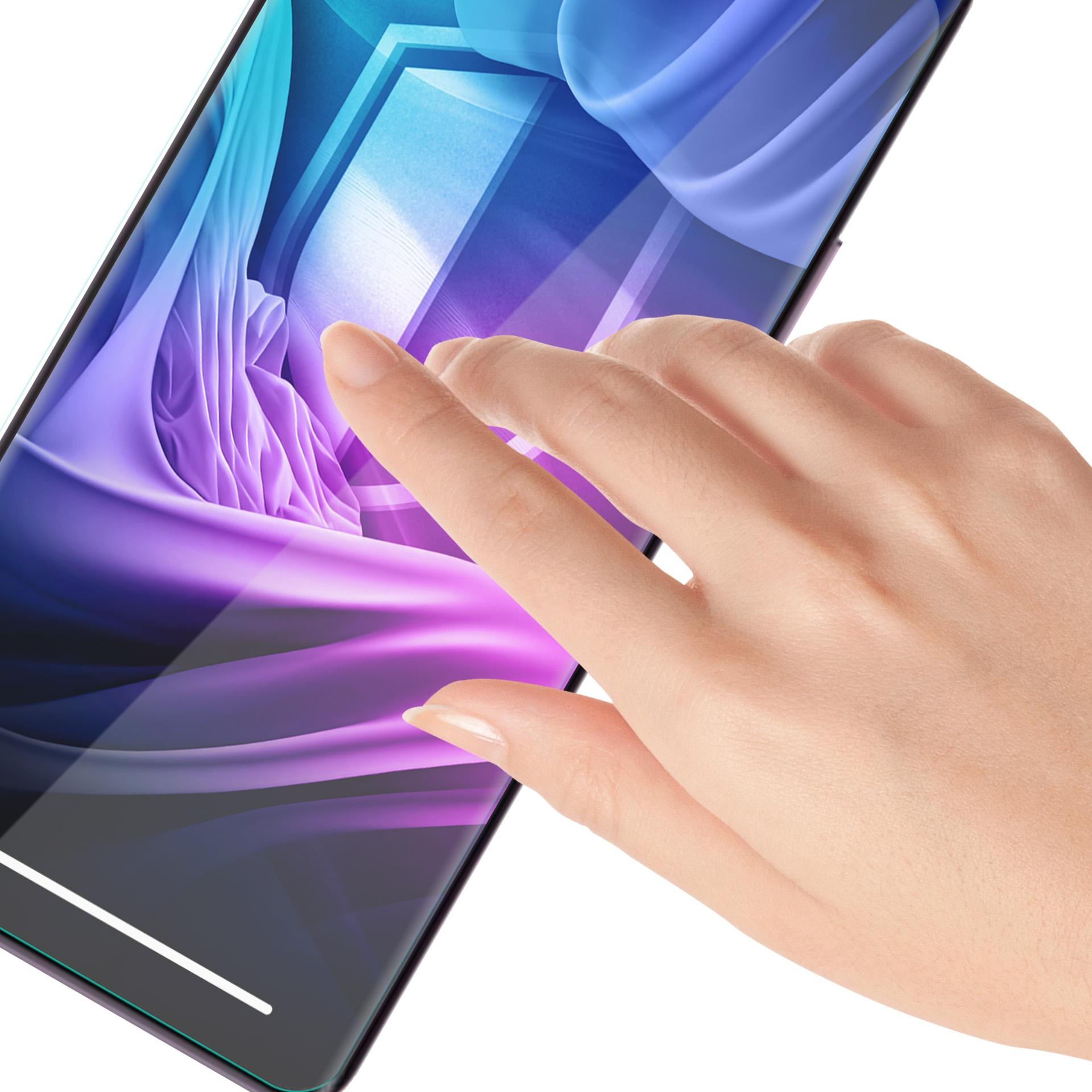 Una mano tocca lo schermo di un telefono. Lo schermo mostra un design astratto viola e blu. Sfondo bianco.