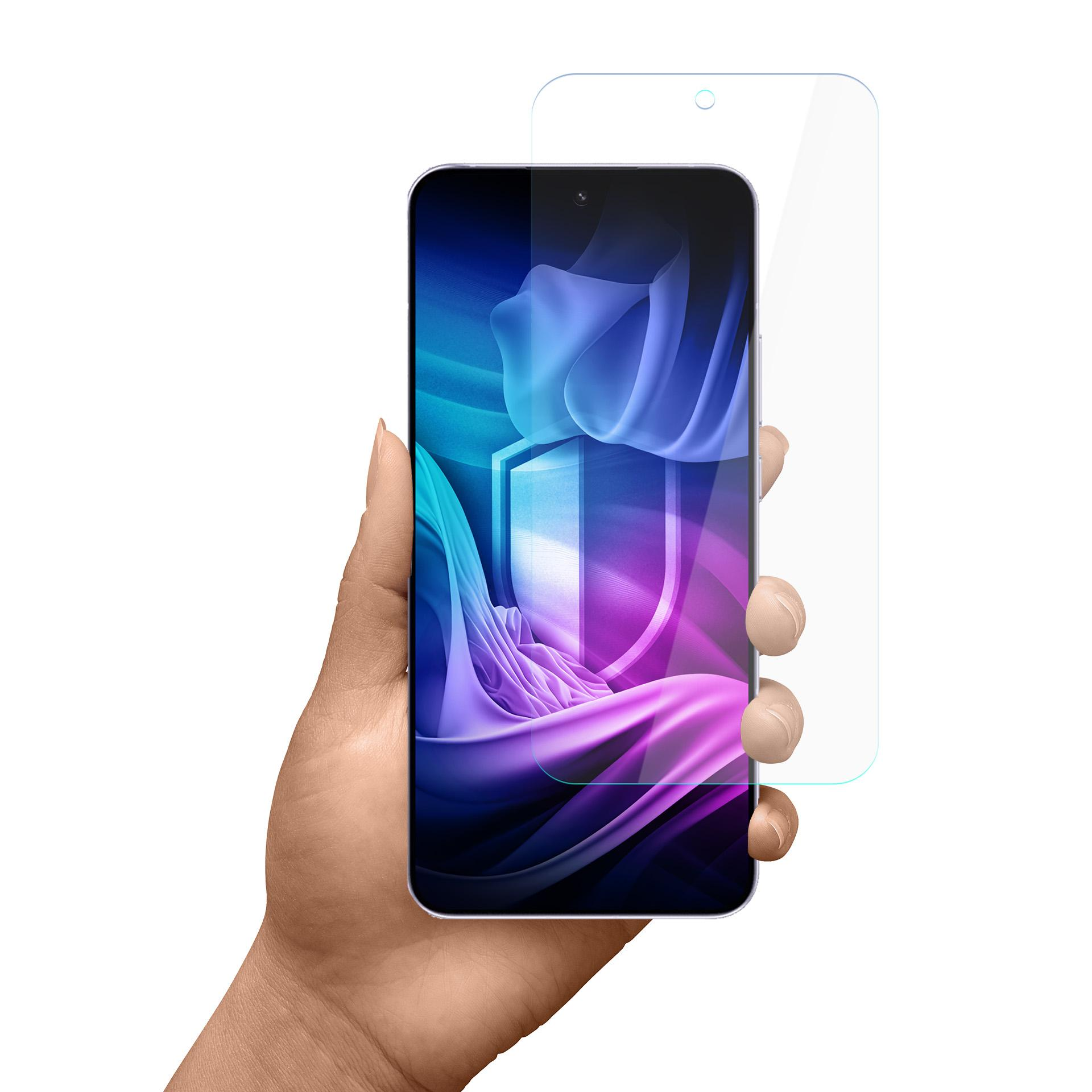 Mano che tiene uno smartphone con protezione schermo. Il telefono mostra un design a scudo. Sfondo bianco.