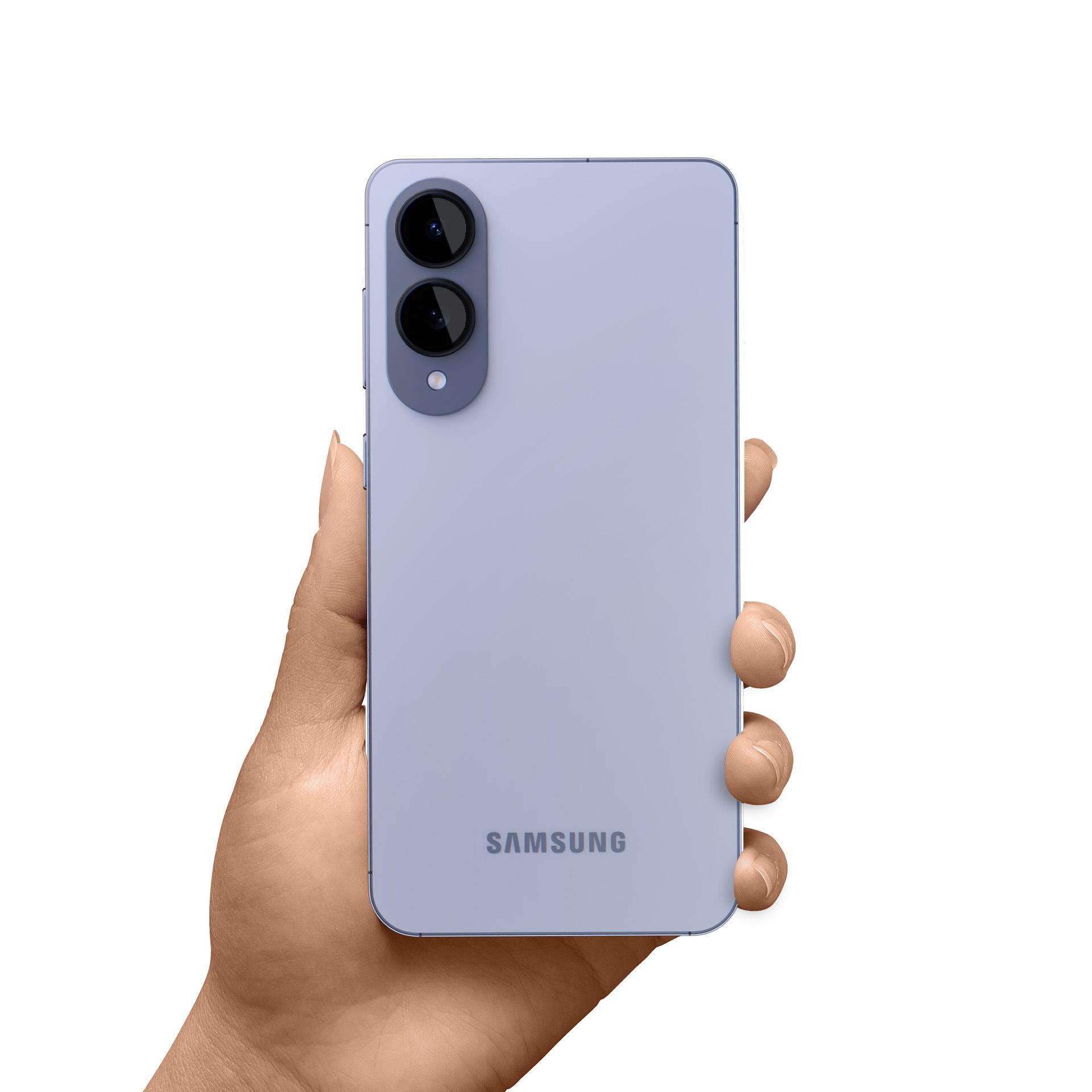 Una mano tiene in mano un telefono Samsung lilla chiaro. Due lenti sono in alto a sinistra. Il logo Samsung è visibile.